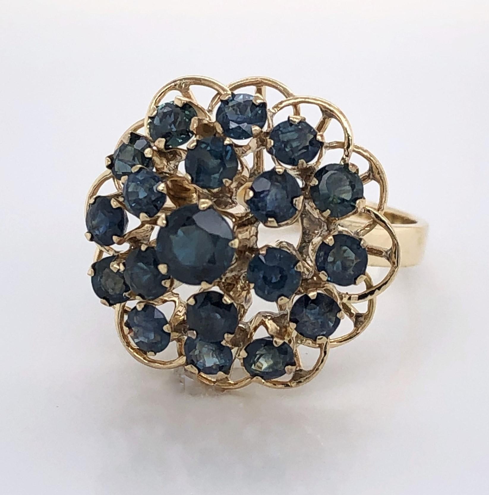 A pyramid of indigo blue sapphires adorn the head of this stunning ten carat 10K  yellow gold cocktail ring. The color and  light, airy placement of the individual prong set stones make this the perfect piece for today's more 