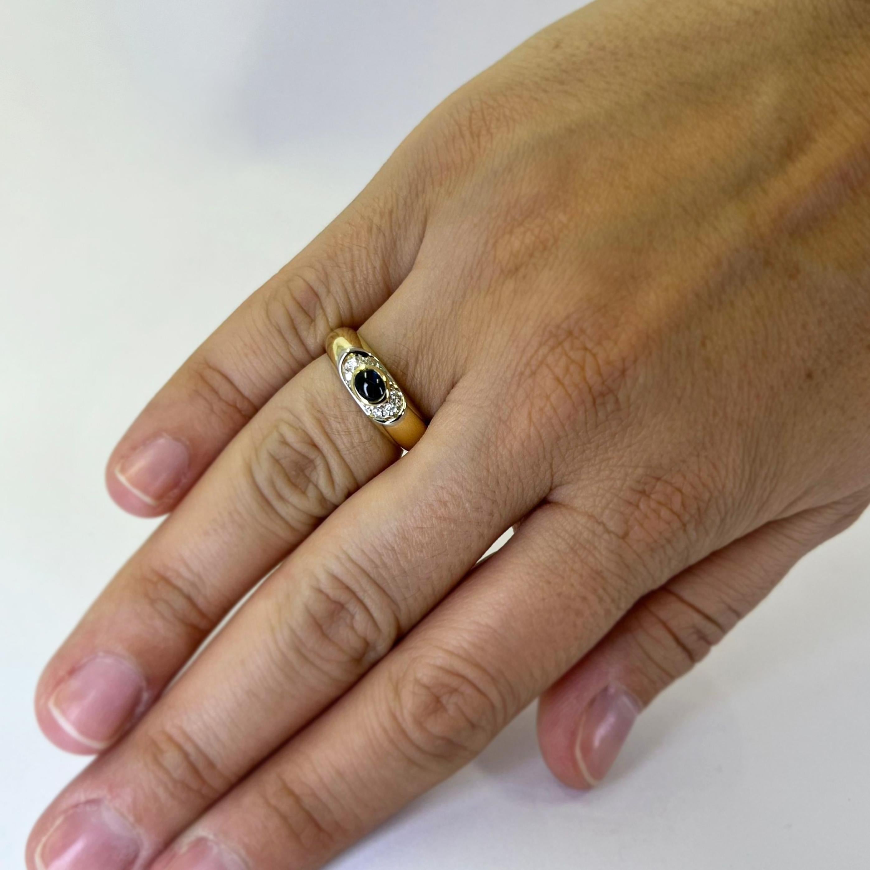 18 karat yellow gold band featuring a 4.5mm x 3mm cabochon sapphire accented by 6 round brilliant cut diamonds of VS clarity and H color totaling 0.06 carats. Finger size 6.5. Includes One Sizing Service Prior to Shipping, Upon Request. Finished