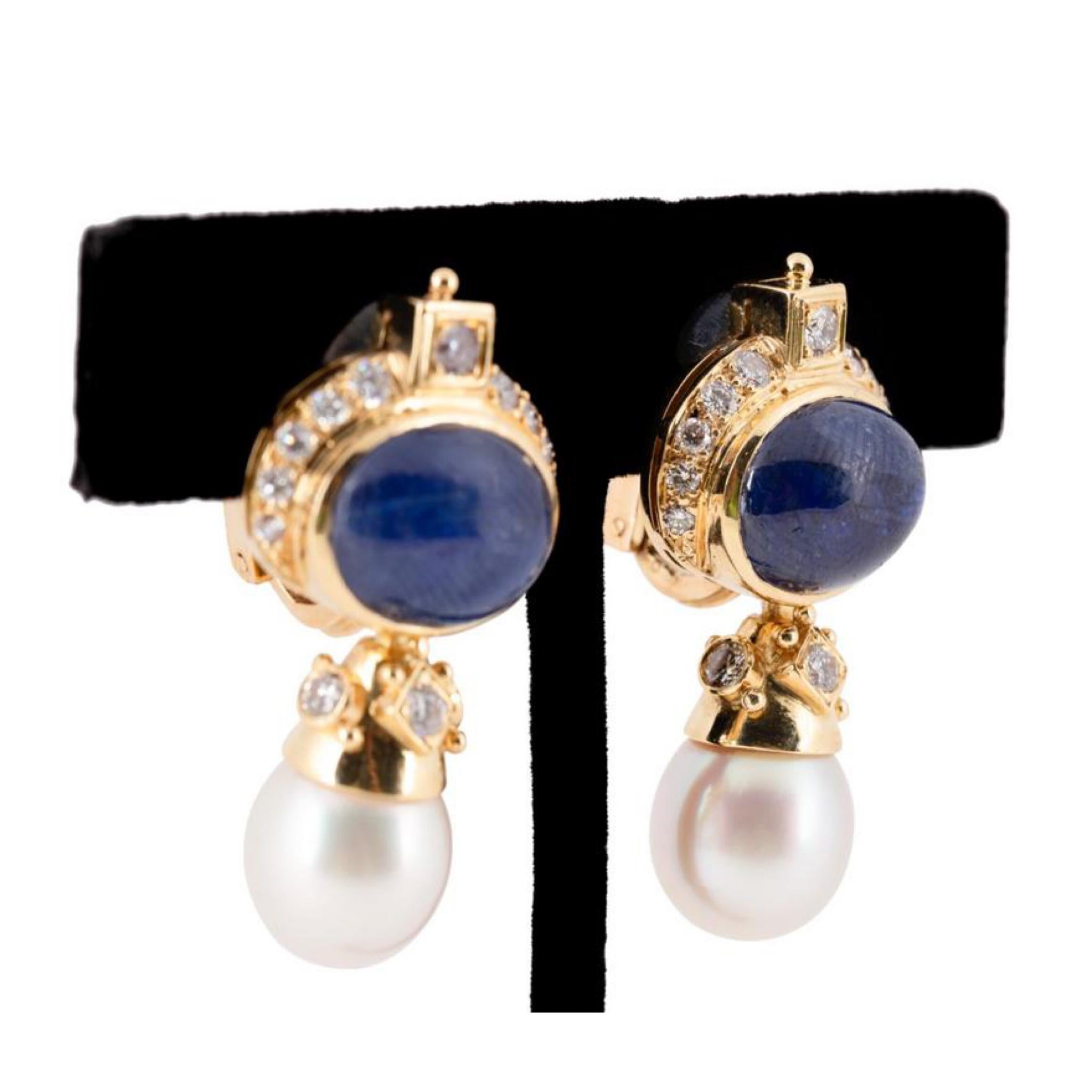 Pair of sapphire, pearl and diamond ear clips in 18k yellow gold, featuring blue sapphire cabochons weighing approximately 18.00 total carats, 12mm white bodied teardrop pearls, and (28) round brilliant cut diamonds weighing approximately 0.85 total
