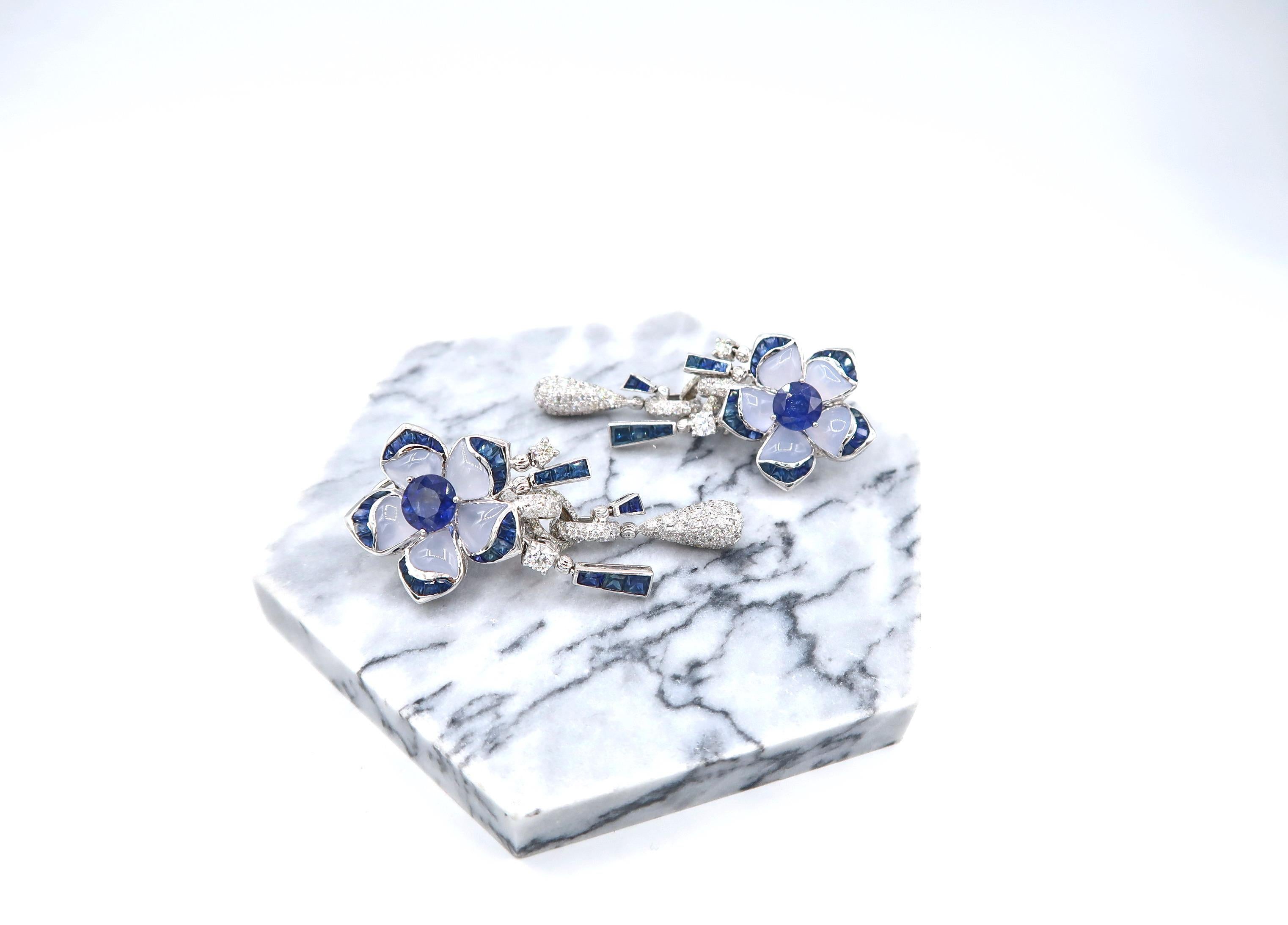 Sapphire Flower Drop Earrings in 18K White Gold with Chalcedony Petals and Sapphire and Diamond Embellishments

Gold: 18K White Gold 28.68g.
Sapphire: 9ct.
Chalcedony: 8.16ct.
Diamond: 3.12ct.