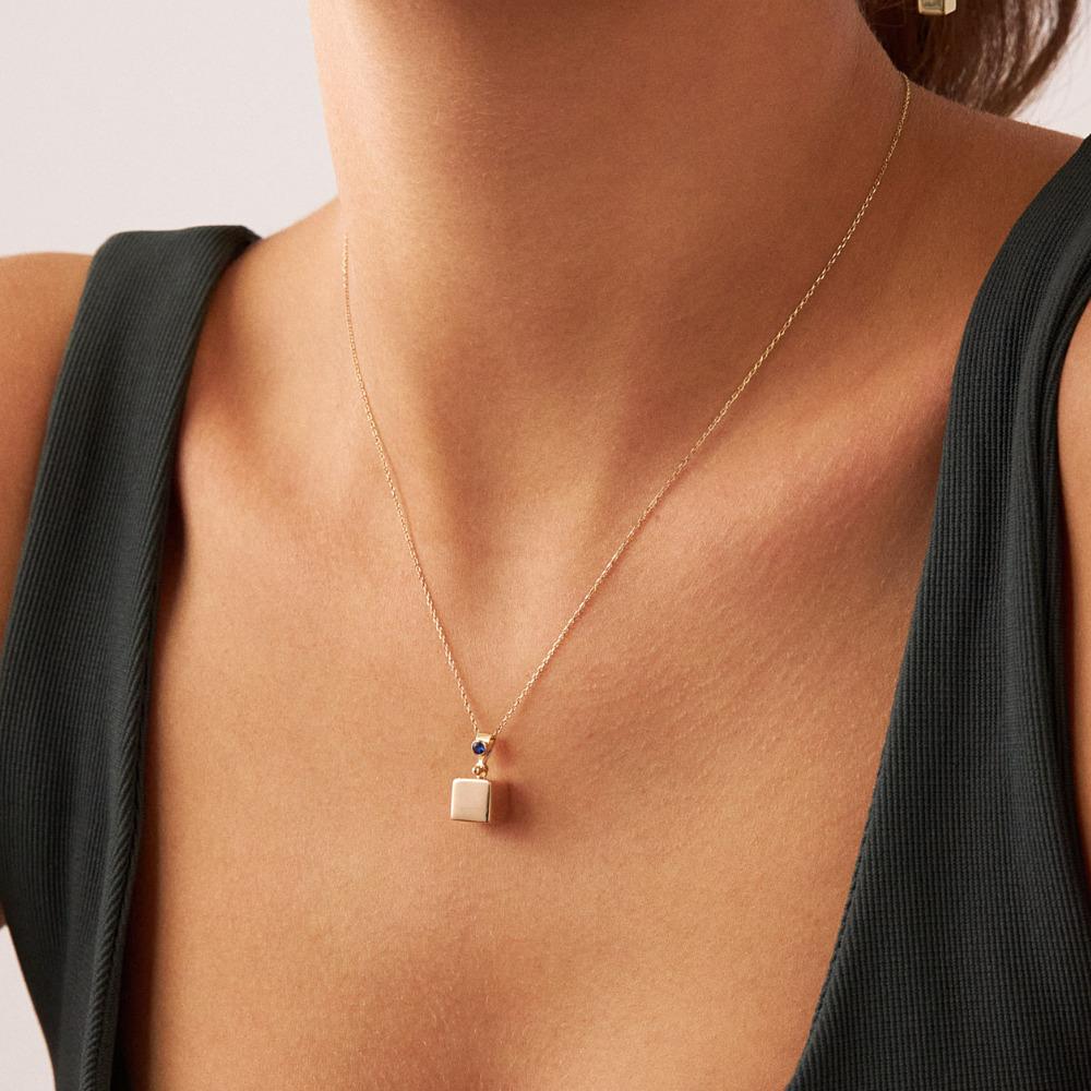 Introducing the 14K Solid Gold Sapphire Cube Necklace, a testament to Orena Jewelry's unwavering pursuit of exceptional artistry. Each necklace is exquisitely handcrafted, radiating a fusion of contemporary luxury and ageless grace. This piece