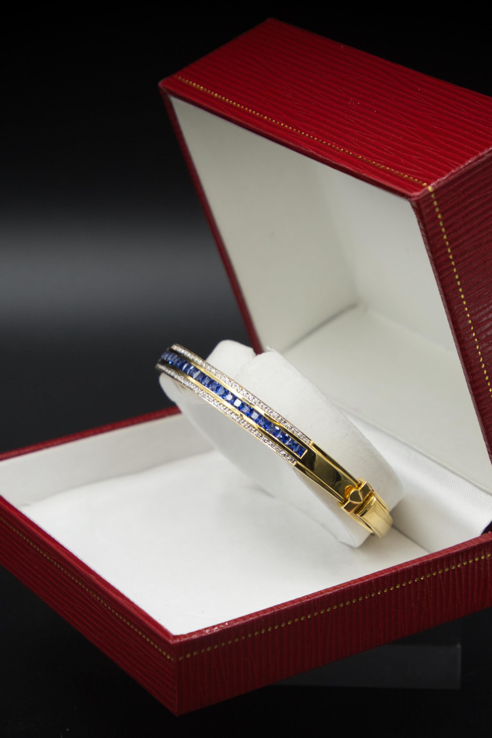 Questo elegante bracciale è realizzato in oro giallo 18 carati e pesa 32,45 grammi. La parte superiore è ornata da zaffiri scintillanti per un totale di 2,46 carati, che offrono una brillantezza blu intenso. Su ogni lato degli zaffiri, ci sono