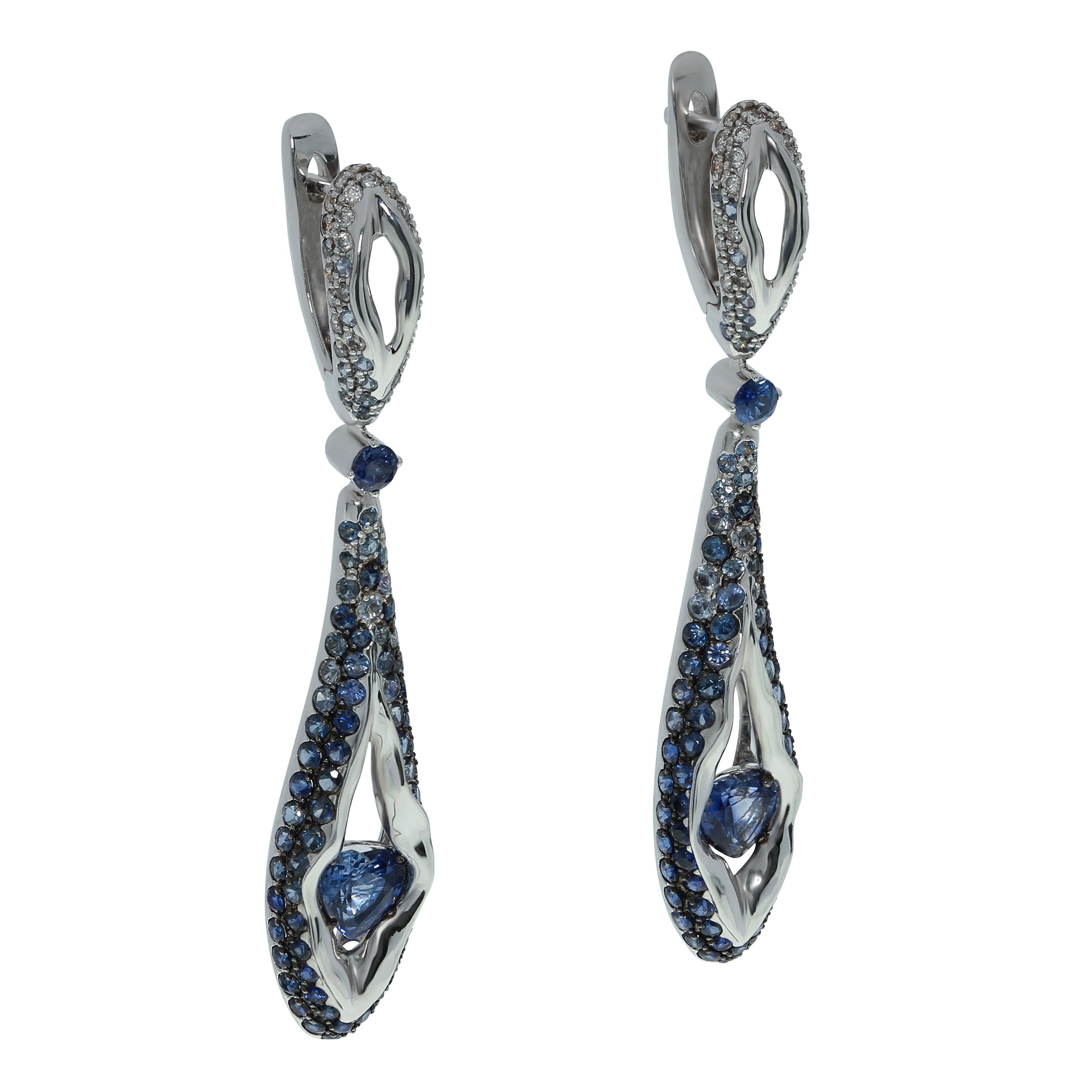 Sapphire Diamond 18 Karat White Gold HeartBeat Earrings
White 18K Gold looks like a rock cracked from strong blows, through which a Blue heart-shaped 1.21 Carat Sapphires makes its way out. From the central stone there are cracks in which is