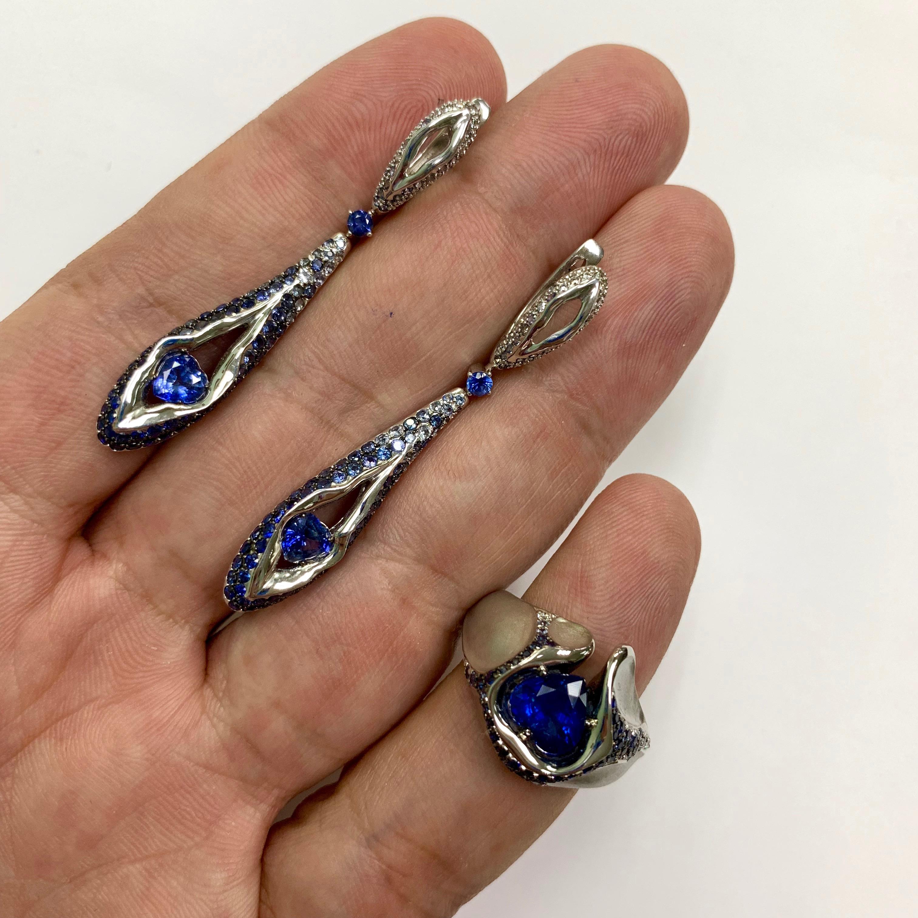 Sapphire Diamond 18 Karat White Gold HeartBeat Ring Earrings Suite
White 18K matte and glossy Gold looks like a rock cracked from strong blows, through which a Blue heart-shaped Sapphire makes its way out. From the central stone there are cracks in