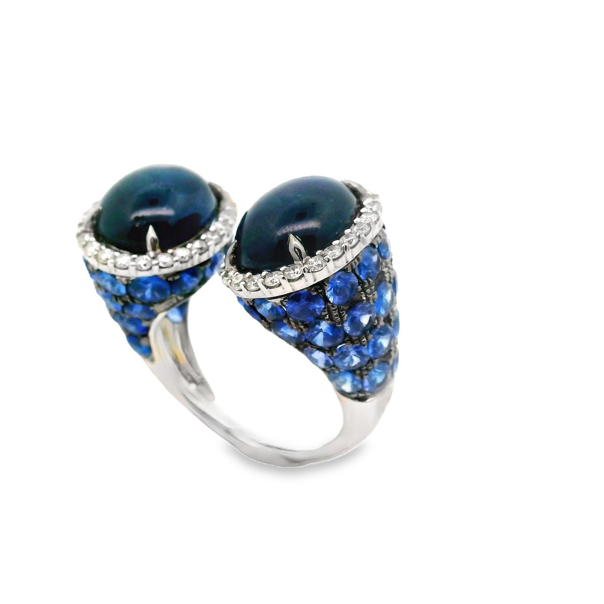 A unique and stylish ring in an open modern style. It features two large cabochon sapphires along with round blue sapphires weighing a total of 17.34 carats. It is accented by 0.72 carats of round brilliant-cut diamonds which add brilliance and