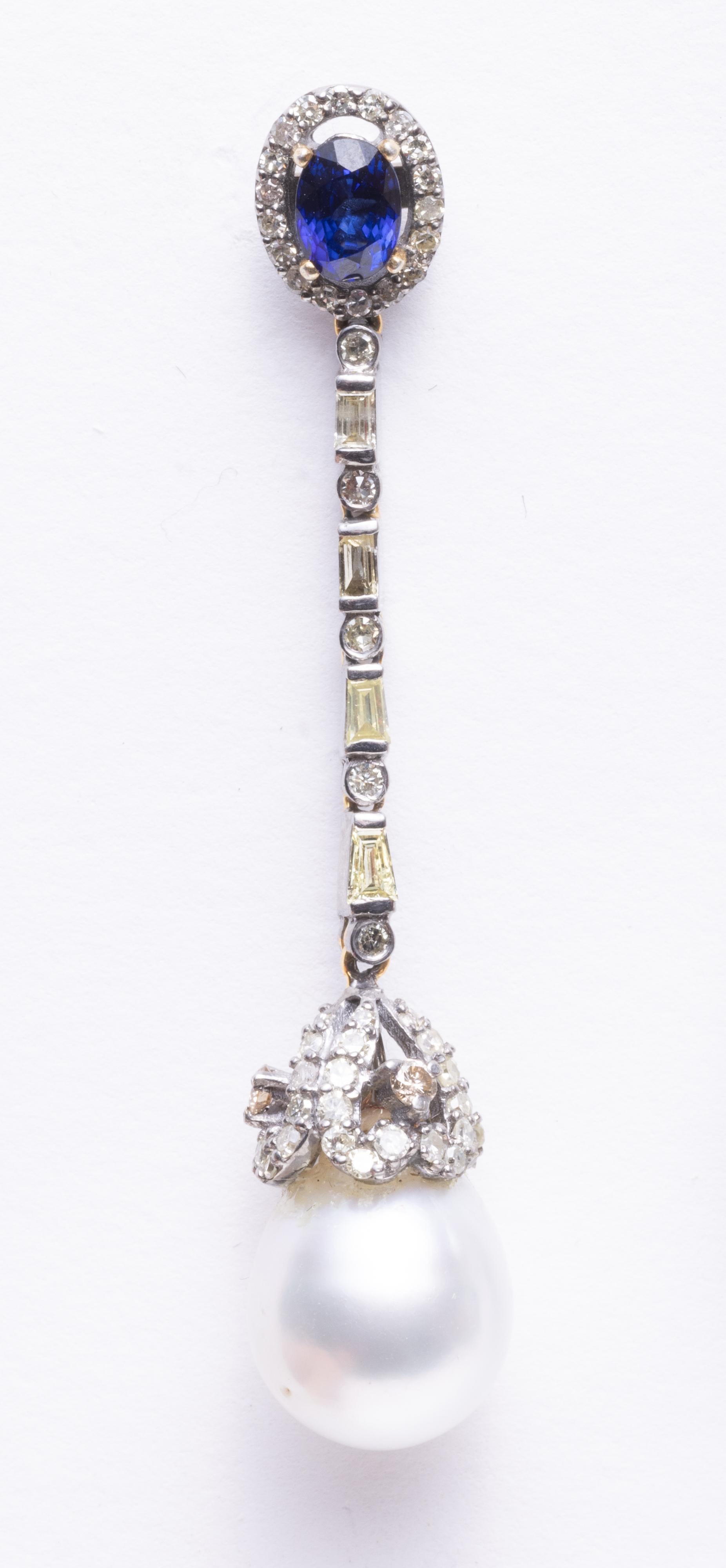 Ein atemberaubendes Paar Ohrhänger mit einem facettierten, ovalen Saphir auf der Stange, umgeben von runden, gepflasterten Diamanten.  Die Kette ist mit Baguette- und runden Diamanten sowie mit Diamanten auf der Endkappe über der birnenförmigen