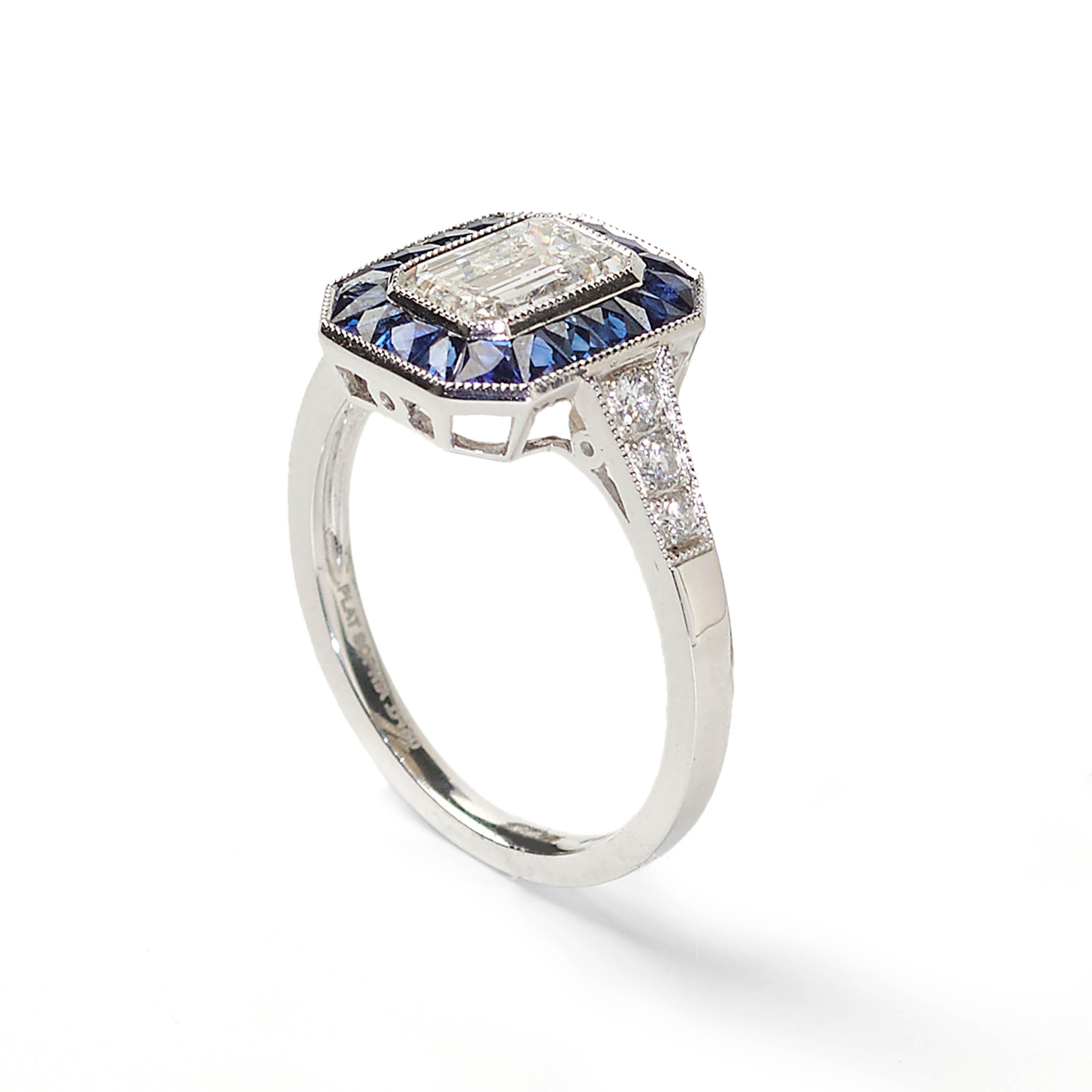 A modern, octagonal-shaped cluster ring set with a central emerald-cut diamond, weighing 1.01 carats, surrounded by a border of sapphires weighing a total of 0.78 carats, with diamonds set to the shoulders weighing a total of 0.16 carats, all