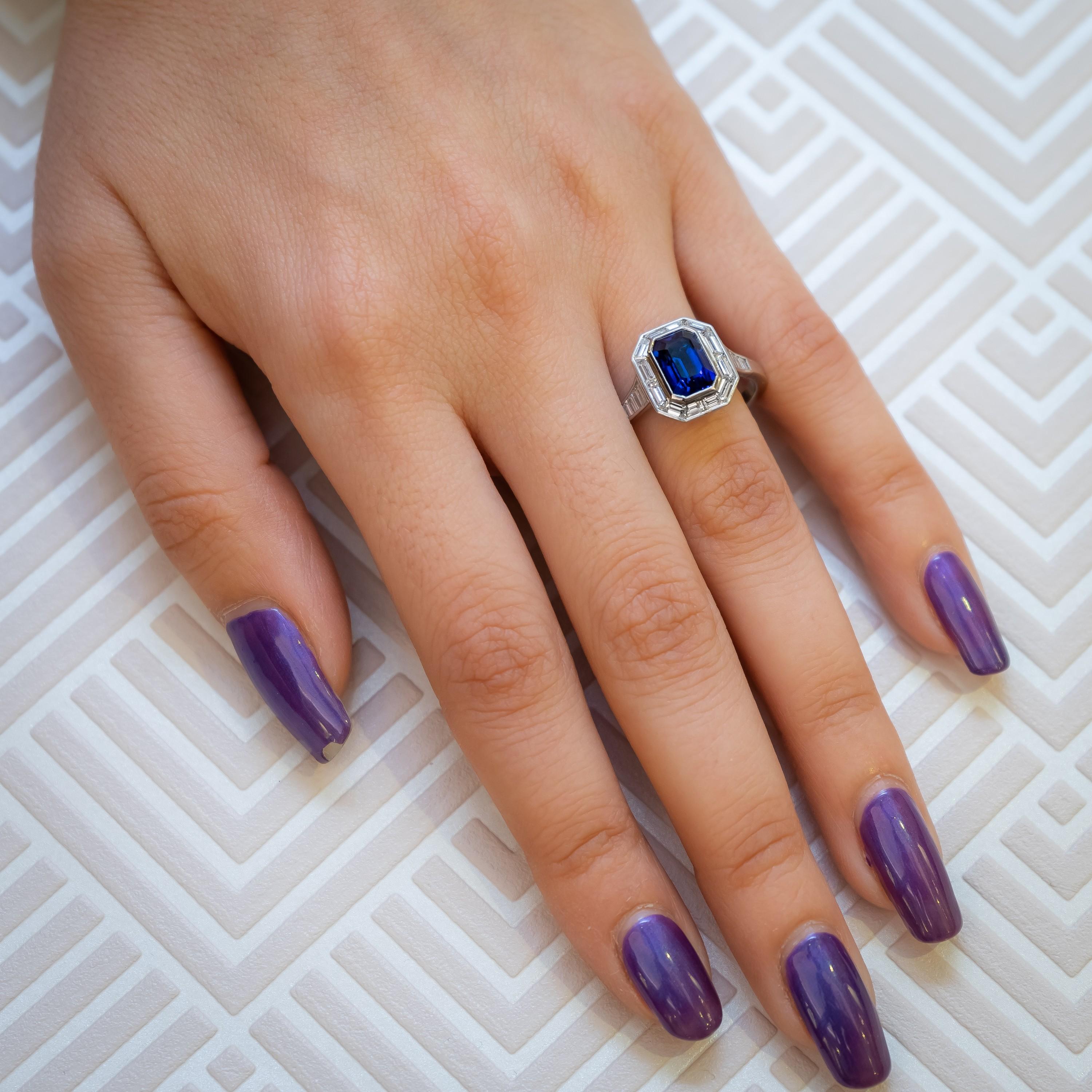 Ein Saphir- und Diamantring auf Gehrung, mit einem Smaragdschliffsaphir, mit einem Gewicht von ca. 2,27ct, in einer Reibefassung, umgeben von Diamanten im Baguetteschliff auf Gehrung, mit Diamanten im Baguetteschliff, die sich an den Schultern