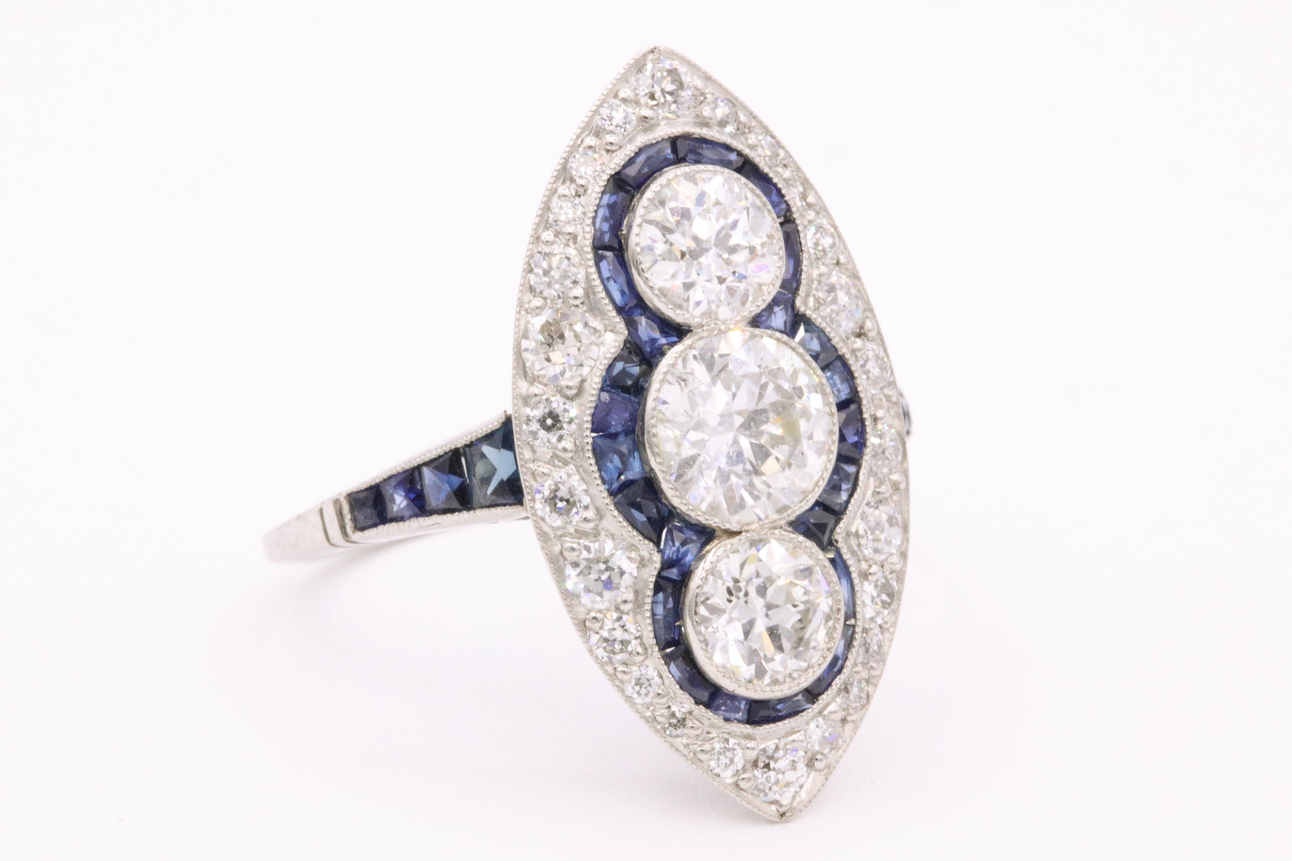 Platinum Art Deco inspired ring featuring three round diamonds weighing approximately 2 carats flanked with blue sapphires weighing approximately 1 carat. Great looking on the finger!

The ring measures 1 inch long and 1/2 inch wide.   