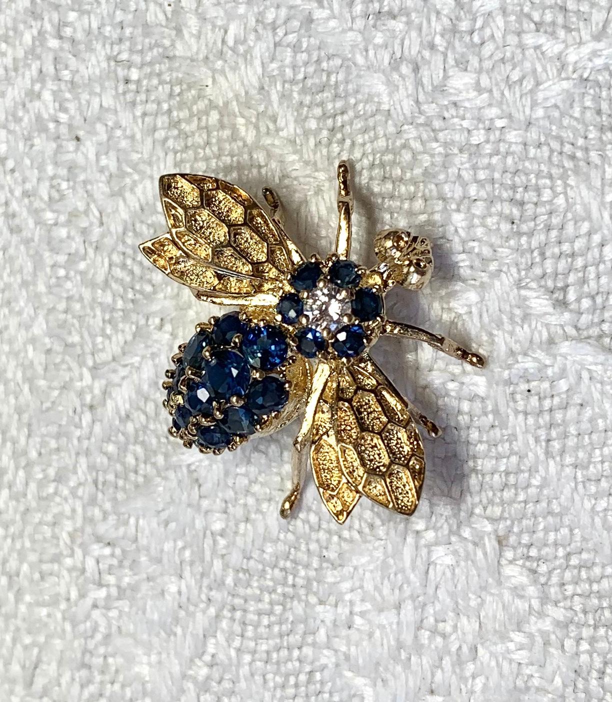 A wonderful Bee Pendant set with 19 gorgeous fine blue Sapphires and a central sparkling white Diamond.  The bee is 14 Karat Yellow Gold.  This whimsical bee dances delightfully around the neck and creates a conversation piece to be passed on for
