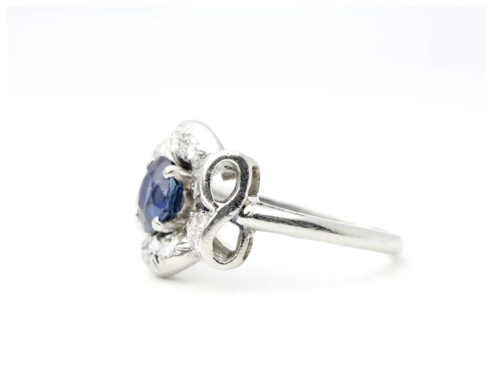 A late Art Deco period sapphire and diamond ring by noted jeweler Maurice Tishman of New York. Centered by a 1.05 Carat old European cut sapphire of beautiful rich blue color, and VS1 clarity. The handmade mounting features a ribbon inspired design,