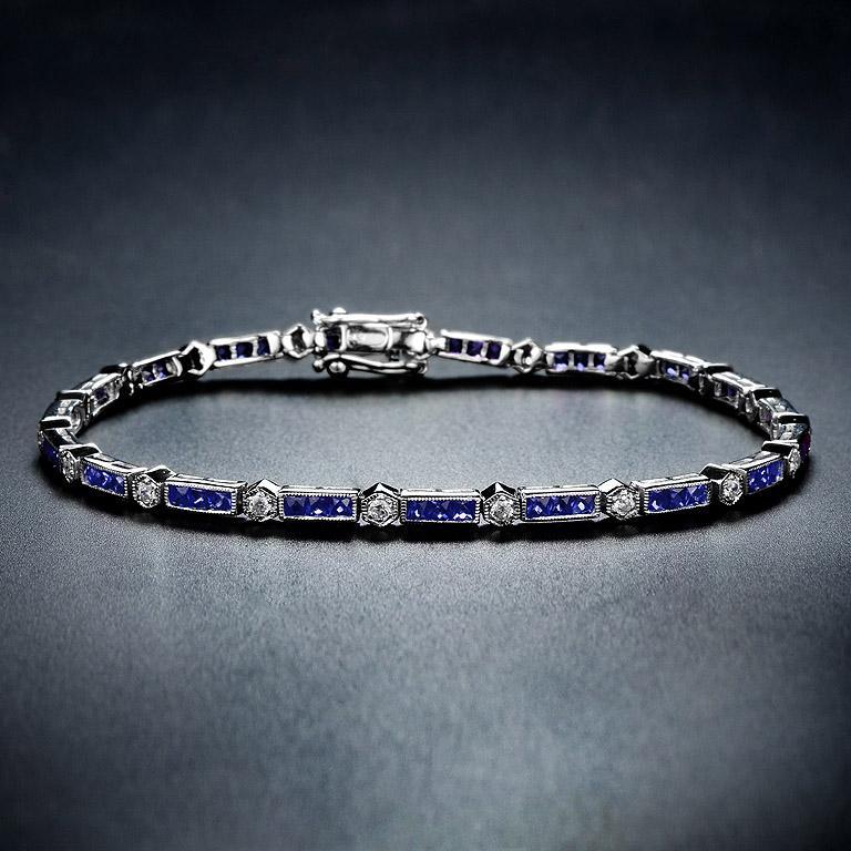 Dieses luxuriöse und farbenfrohe Armband ist abwechselnd mit blauen Saphiren im Dreifach-Baguetteschliff und runden Diamanten im Brillantschliff besetzt. Das 18-karätige Weißgold verleiht dem klassischen Art-Deco-Stil Sicherheit, und ein