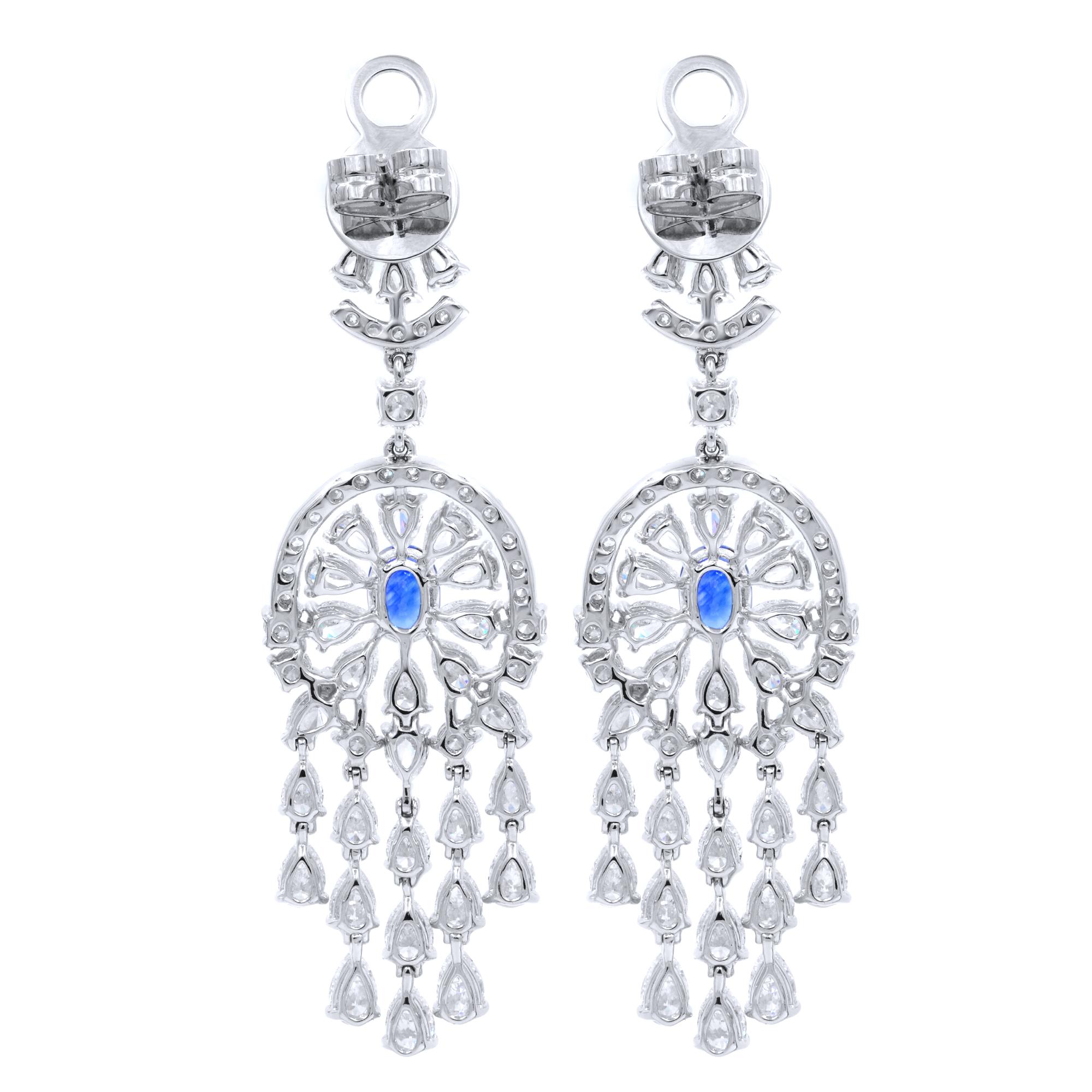Beautiful diamond earrings make a statement outfit look complete. These classic diamond drop earrings are a lovely combination of 12.80 carat of natural diamonds and  2.05 carat of blue sapphires. The 18k white gold setting is nice compliment to the