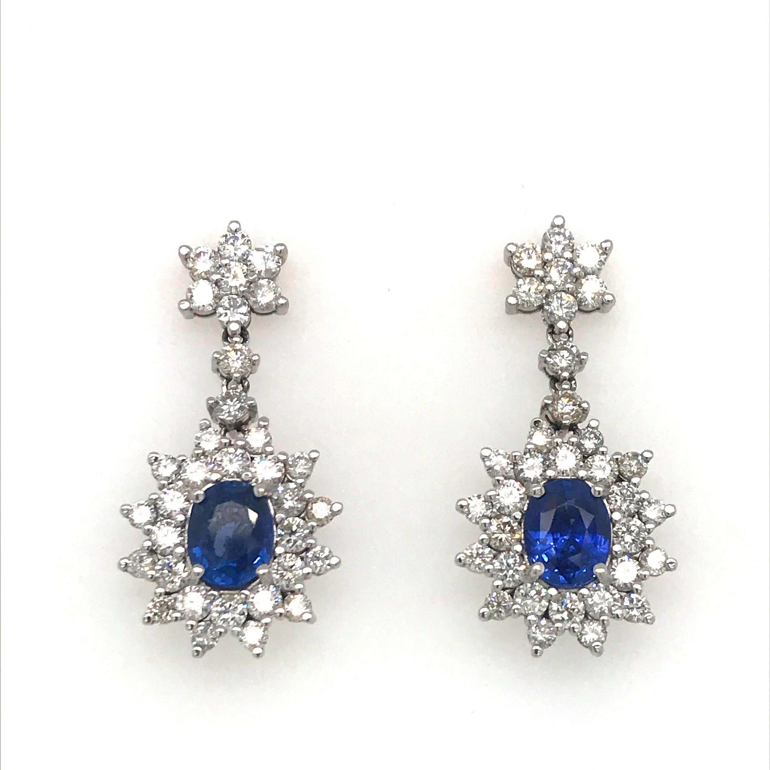 18K White gold drop earrings featuring two oval sapphires weighing 3.40 carats flanked with round brilliants weighing 3.65 carats.
Color G-H
Clarity SI