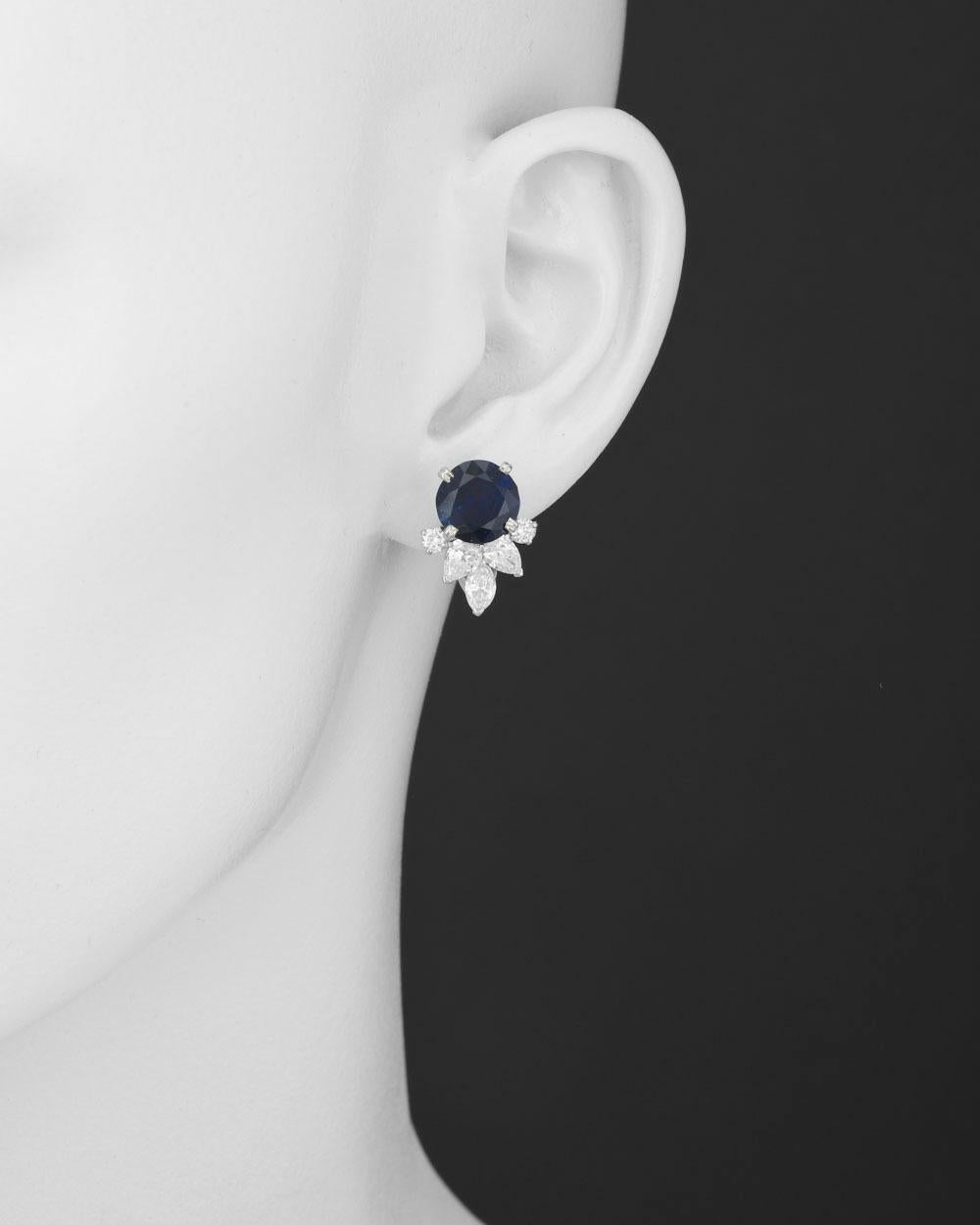 Sapphire and diamond cluster earrings, designed with a larger round sapphire surmount accented by a trefoil cluster of pear-shaped diamonds at base flanked by a pair of smaller round diamonds, the sapphires weighing 7.46 total carats, mounted in