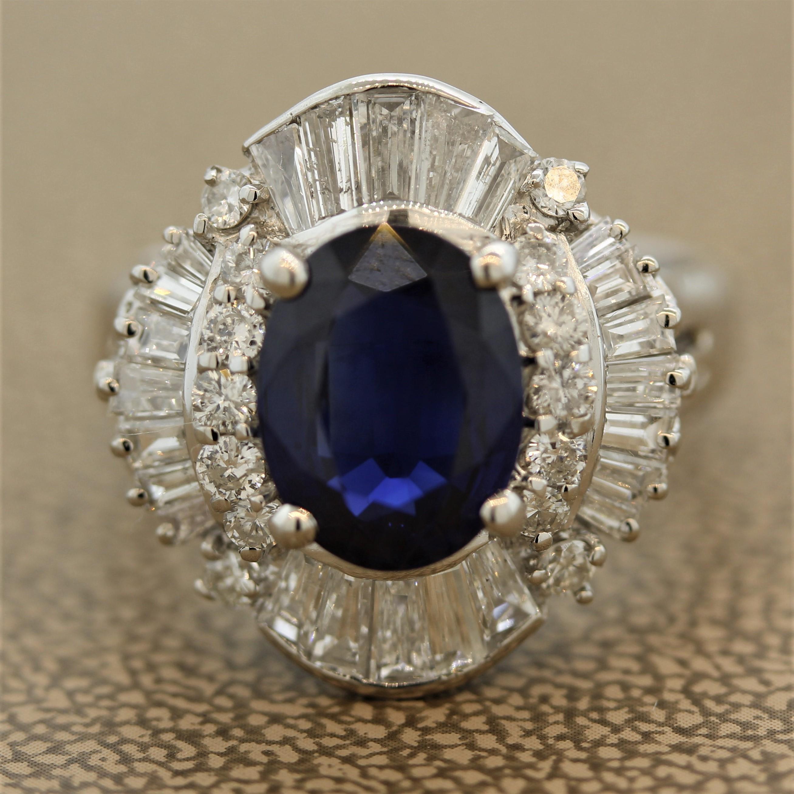 A classic sapphire and diamond cocktail ring. The oval shaped sapphire weighs 3.30 carats and has a rich even blue color. It is surrounded by a cluster of round brilliant and tapered baguette cut diamonds which weigh a total of 1.48 carats. Hand