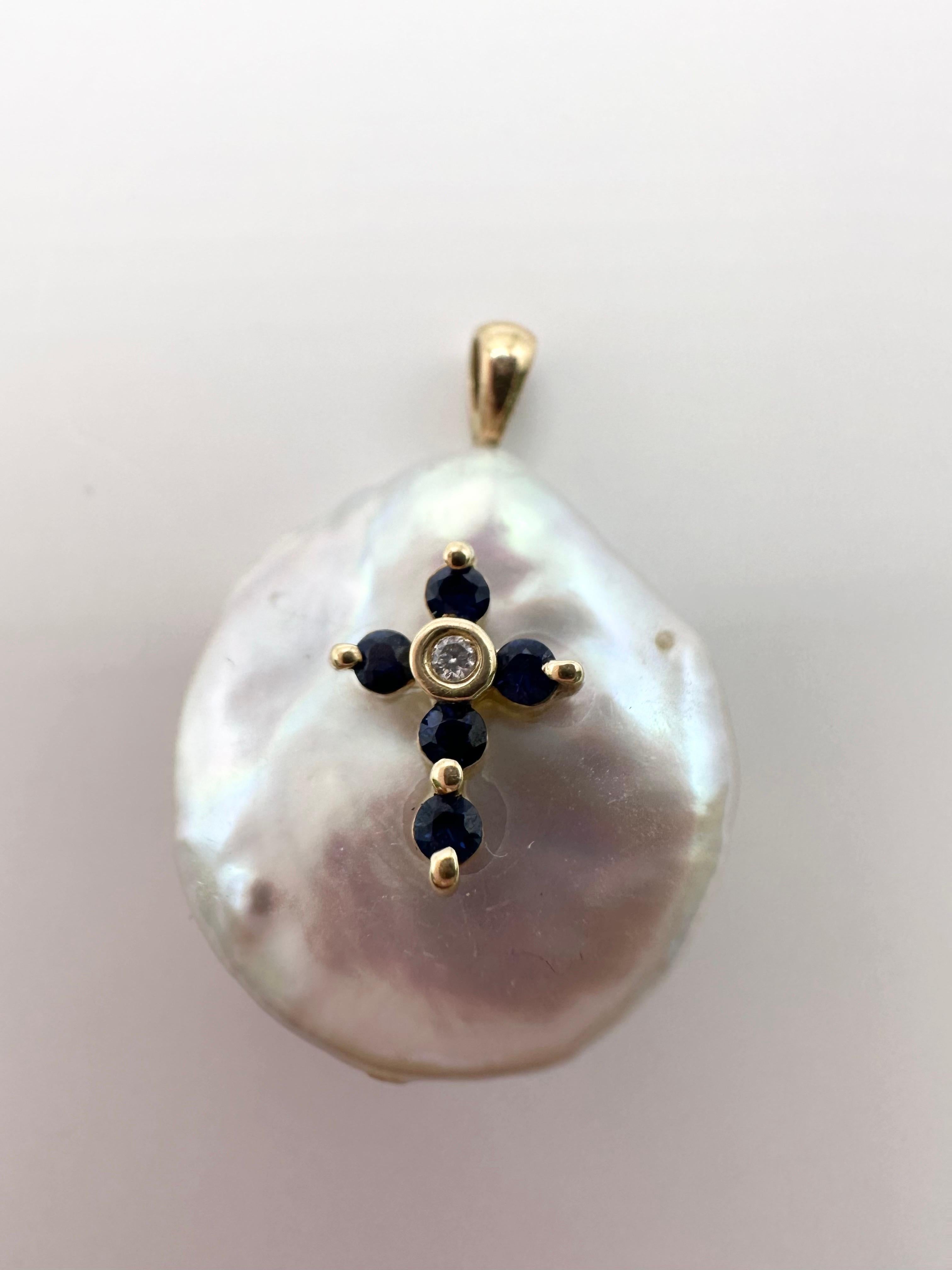 Baroque natural pearl with natural sapphires cross pendant, this piece is made with quality not glued but rather assembled all together to make a unique jewelry statement in 14Kt gold.

Metal Type: 14KT

Natural Sapphire(s): 
Color: Blue
Cut:Round