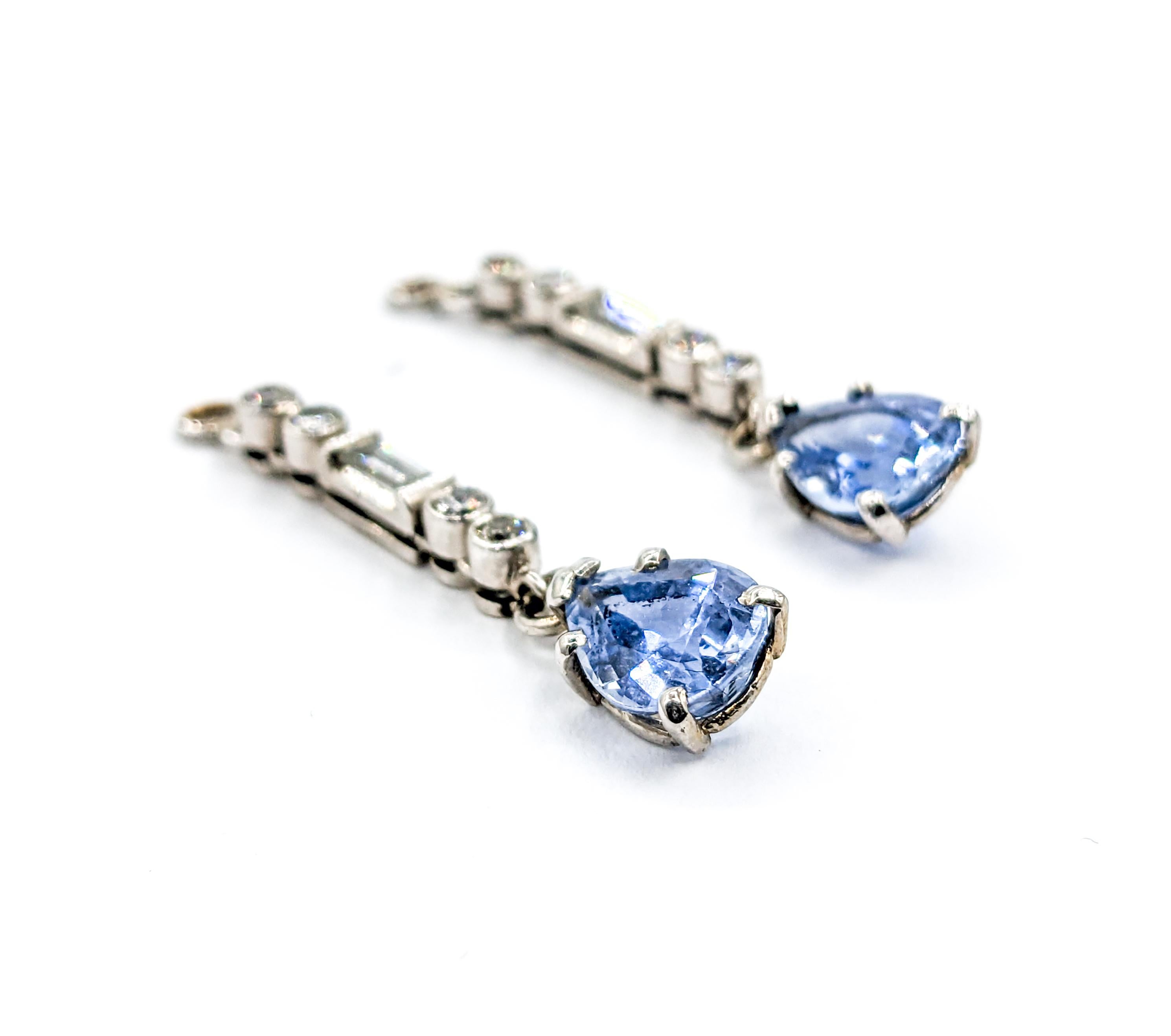 Sapphire & Diamond Dangly Earrings In White Gold

Discover the allure of these stunning earrings, expertly crafted in 14kt White Gold, featuring a .30ctw blend of Round & Baguette Diamonds. These diamonds, dazzling with SI1 clarity and G-H color,