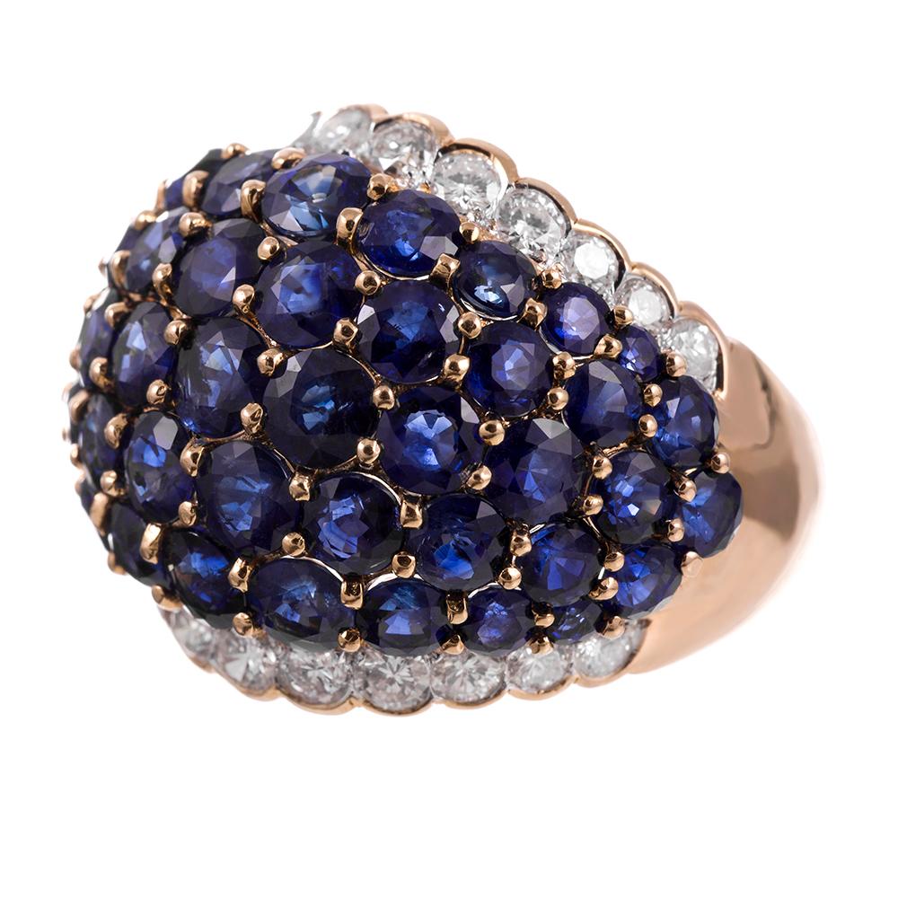 A deep blue centerpiece of graduated sapphires is set perfectly between two rows of brilliant round-cut diamonds. An 18k yellow gold setting brings added dimension to this ring with warm contrast and symmetry. The subtle dome-shape of this cocktail