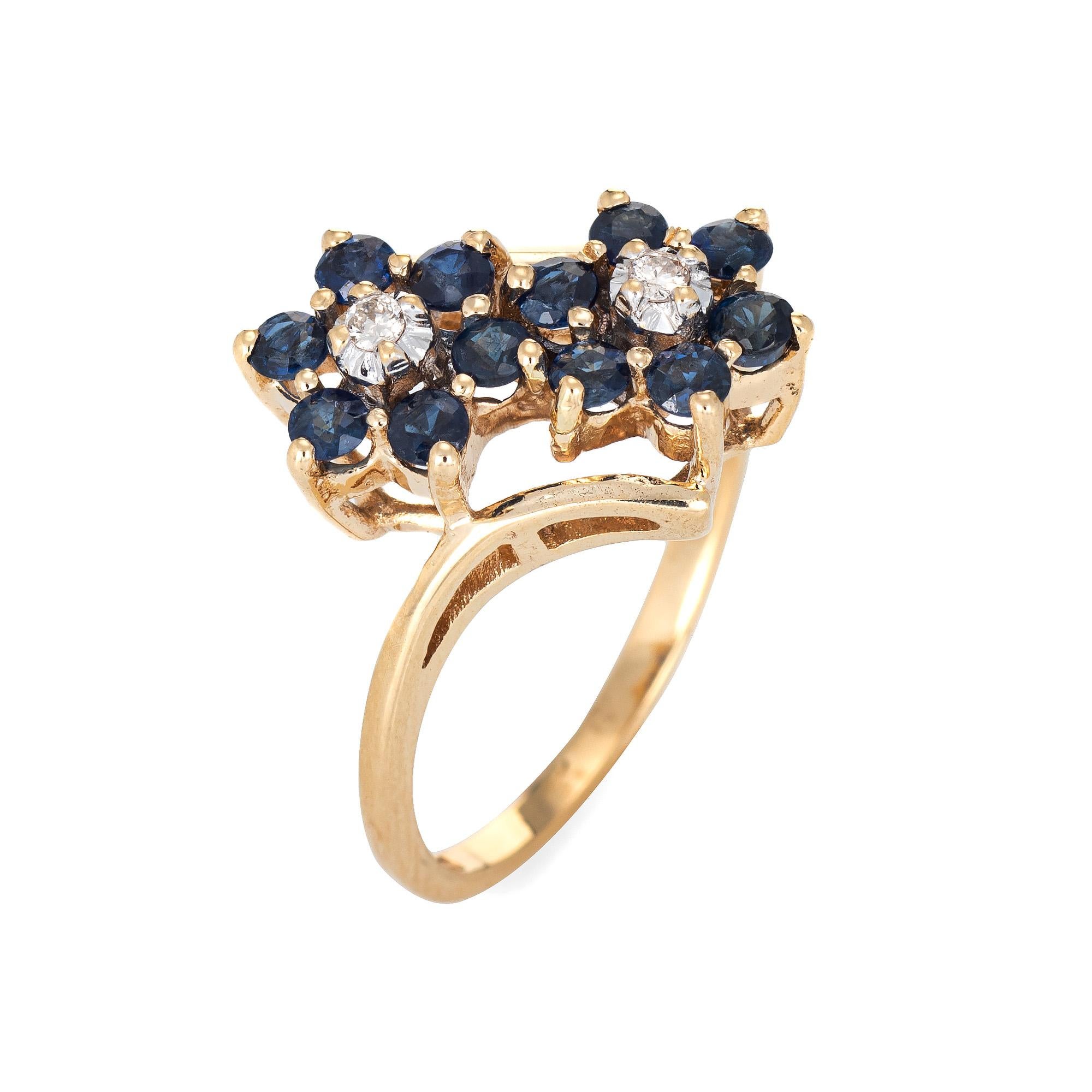 Fein detaillierter Vintage-Saphir & Diamant-Doppelblumenring aus 10 Karat Gelbgold. 

Zwei runde Diamanten im Brillantschliff mit einem geschätzten Gewicht von je 0::03 Karat ergeben insgesamt 0::06 Karat (geschätzte Farbe I-J und Reinheit I1). 12