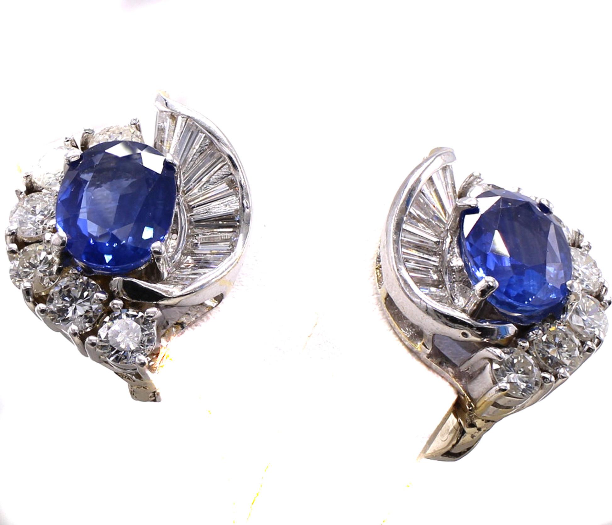 Beautifully designed clip-on earrings with a pair of perfectly matched oval deep blue well saturated sapphires weighing approximately 3 carats total. Embellished by bright white sparkly round brilliant cut and baguette cut diamonds weighing