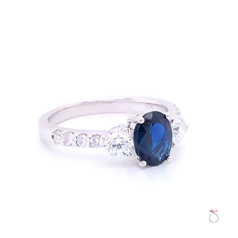 Beautiful Blue Sapphire & diamond engagement ring in 14K white gold. This gorgeous ring features a stunning oval shape blue Sapphire in the center set in four prongs and flanked by two round brilliant cut diamonds, one on each side. The Sapphire