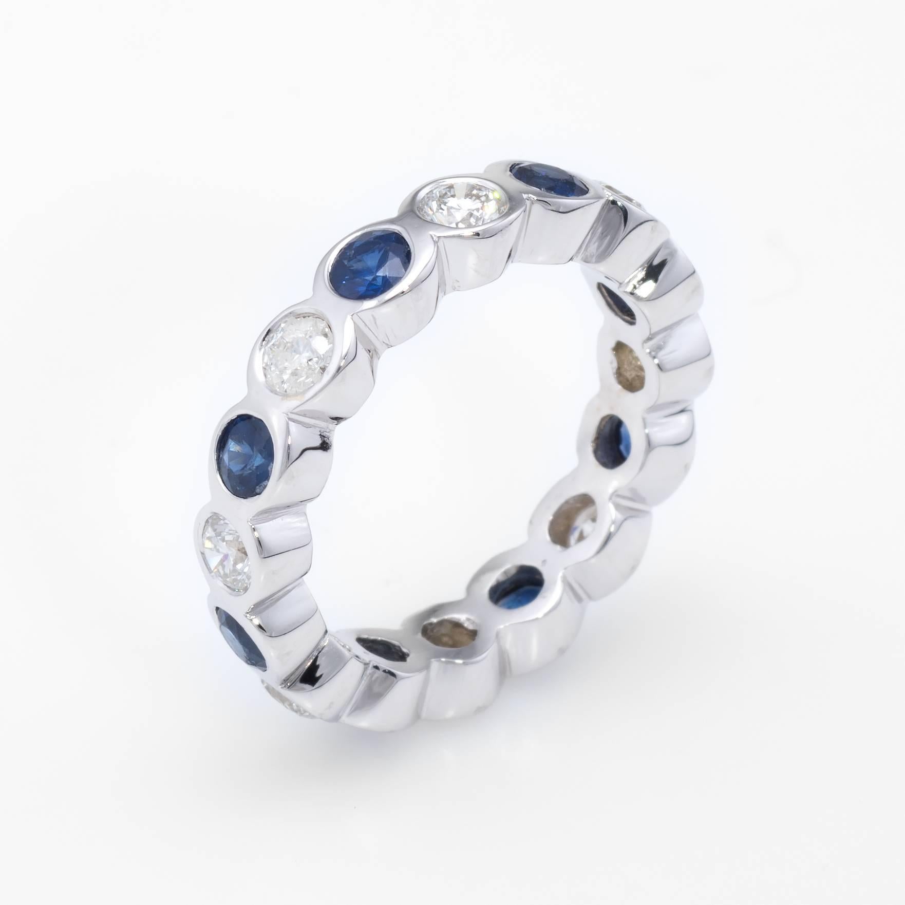 Elegant estate eternity ring, crafted in 18 karat white gold. 

Sapphires measure 3mm each and total an estimated 1.20 carats, accented with an estimated 0.88 carats of round brilliant cut diamonds (estimated at I-J color and SI1-2 clarity).   

The