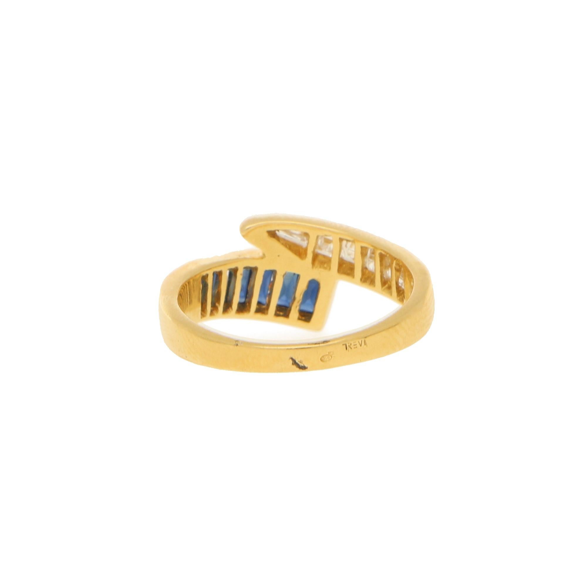 A sapphire and diamond half-eternity ring set in 18 karat yellow gold. 

The piece is designed as a half-eternity ring of a fancy crossover design, one side channel-set with calibre baguette-cut sapphires and the other side with calibre carre-cut