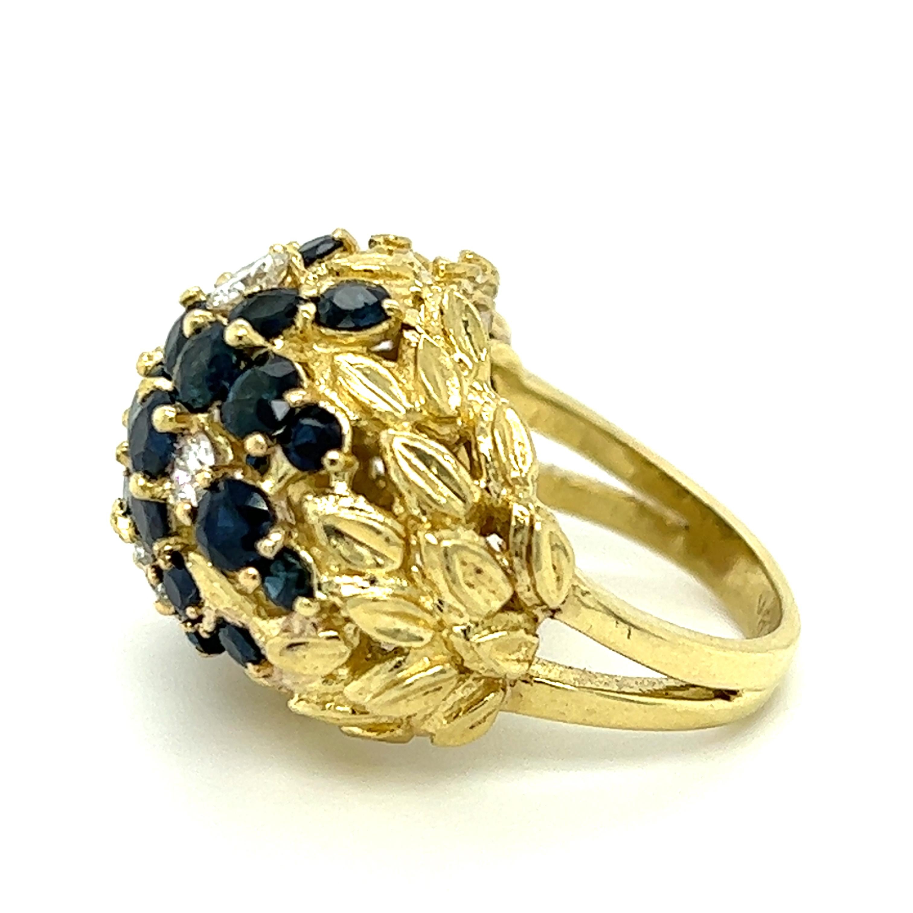 One 18 karat yellow gold (stamped 18K) carved flower design dome ring set with four (4) modern round brilliant cut diamonds, approximately 0.70 carat total weight with matching I/J color and SI1 clarity and twenty-six (26) round natural dark blue