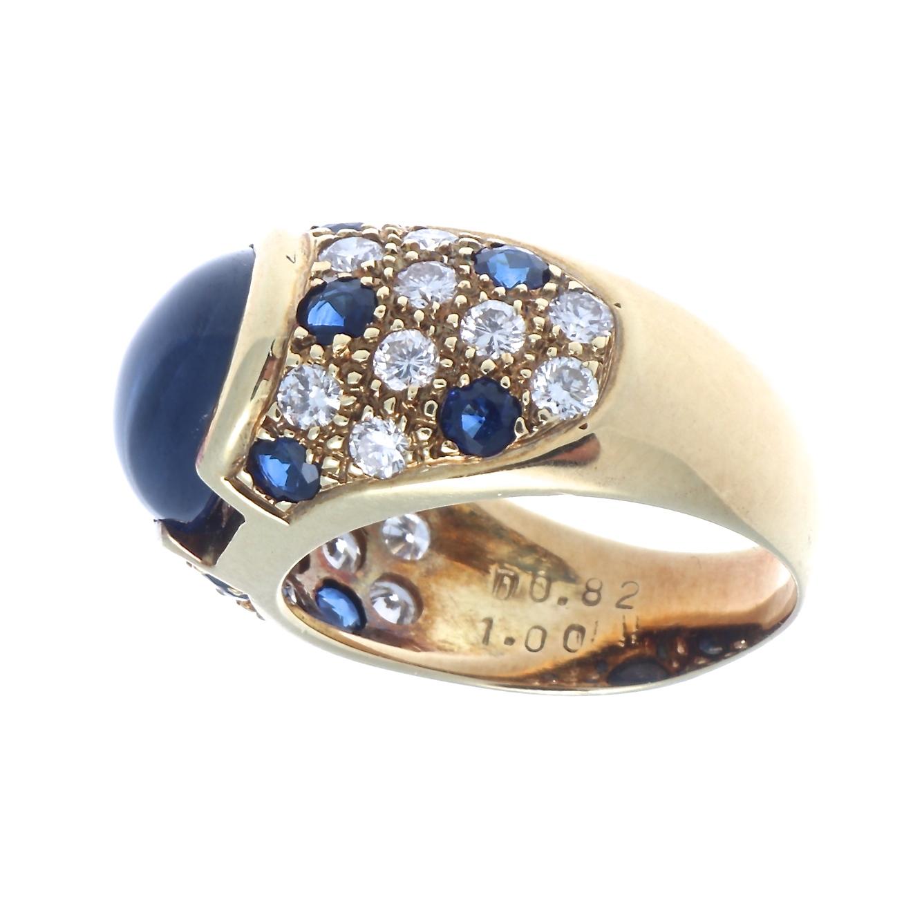Bold yet graceful, a look that inspires commentary on the nature of feminine power.  Featuring a royal blue cabochon cut sapphire accented with diamonds and sapphires. Crafted in 18k gold. Ring size 6-3/4 and can easily be resized to fit, if needed