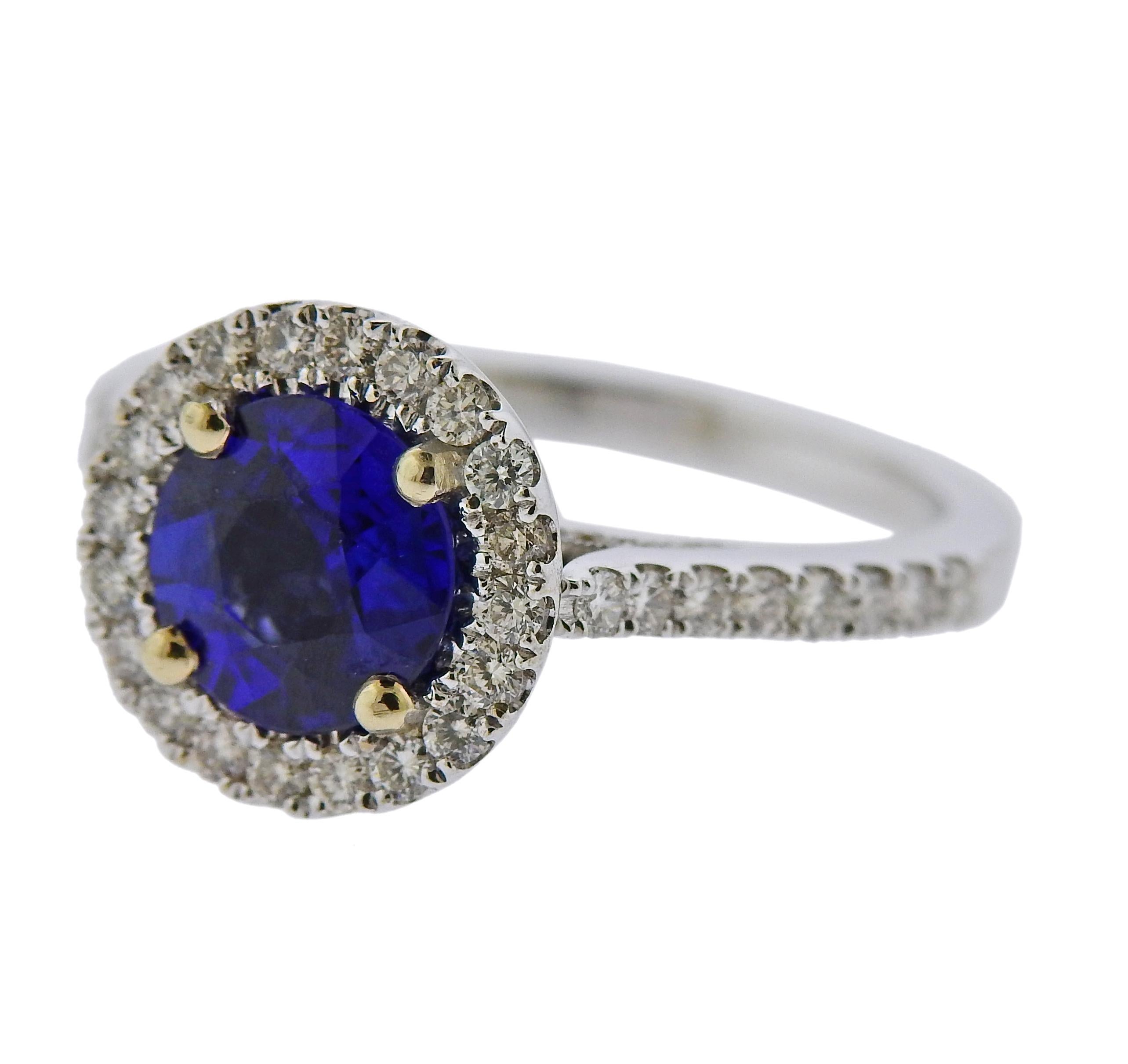 Modern 18k gold engagement ring, featuring round blue sapphire in the center ( 7.7mm in diameter), surrounded with 0.83ctw in diamonds. Ring size 6.75, top is 12mm in diameter. Marked D0.83, k18.  Weighs 4.5 grams.