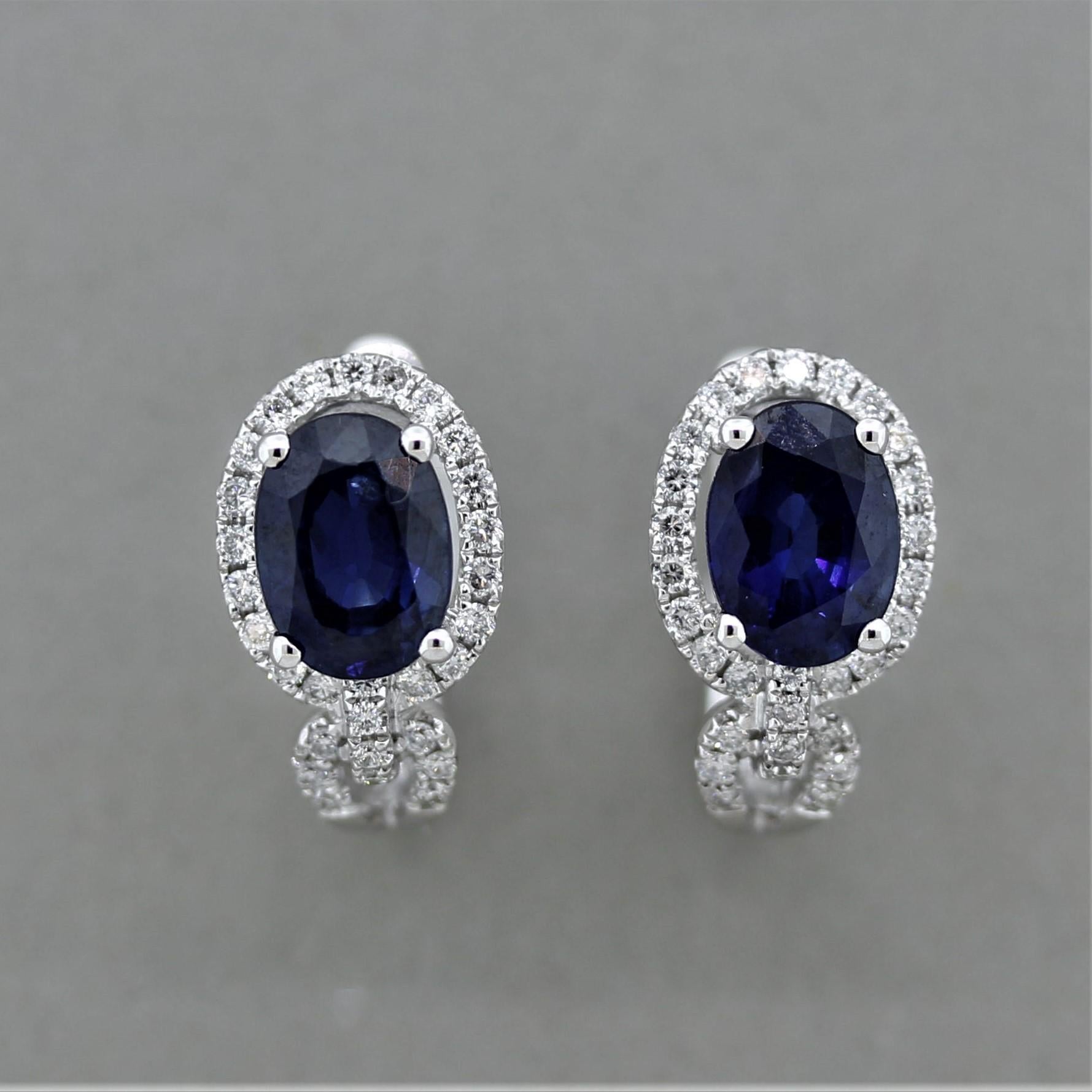 A lovey pair of gold huggie earrings featuring 2.03 carats of oval shaped blue sapphires and 0.29 carats of round brilliant cut diamonds. Made in 18k white gold and ready to be worn!

Length: 0.5 inches