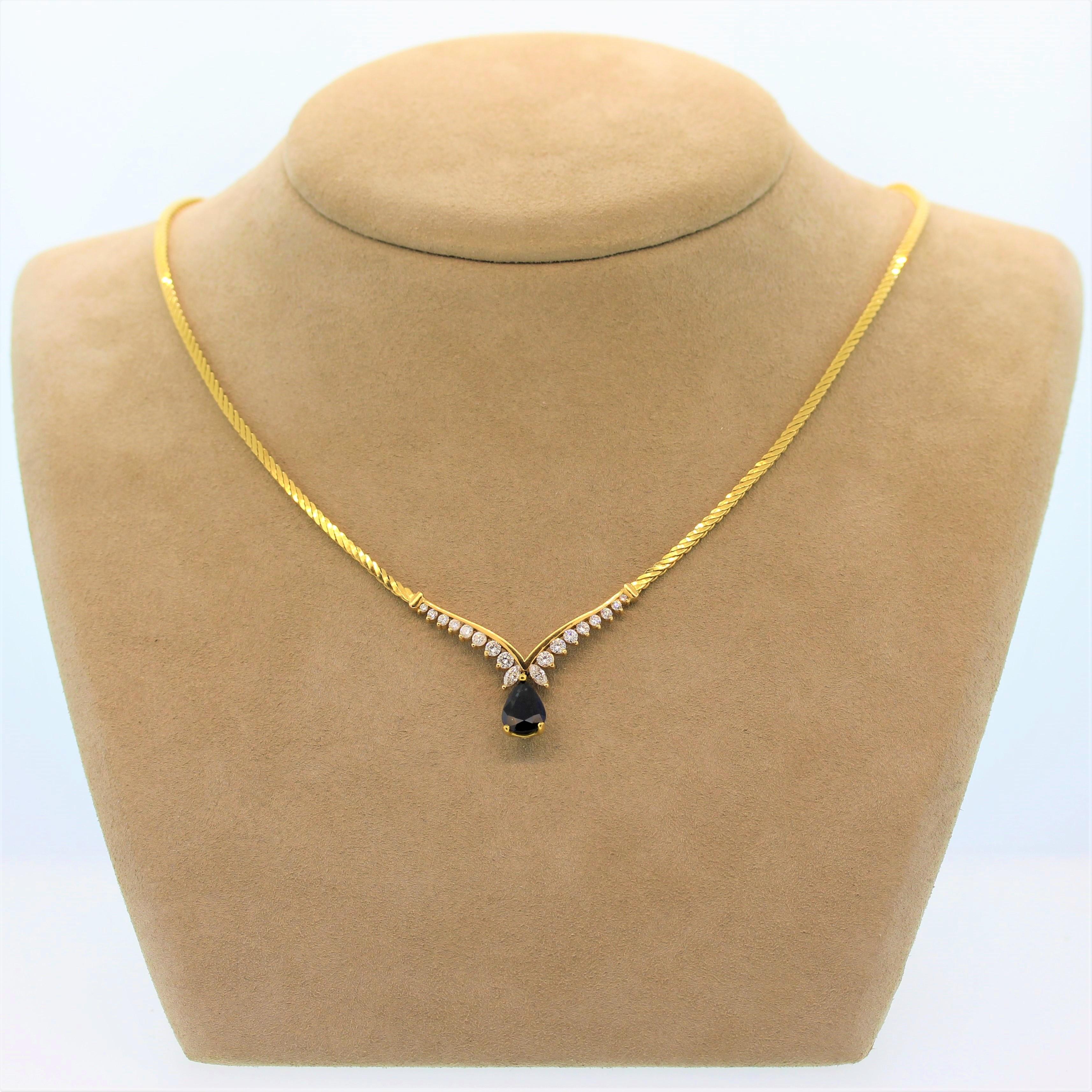 This timelessly elegant necklace features a blue sapphire of approximately 1.50 carats. The pear shape sapphire drops from a 14K yellow gold setting with 1.04 carats of marquise and round cut diamonds in a graduating pattern. The chain is a twist