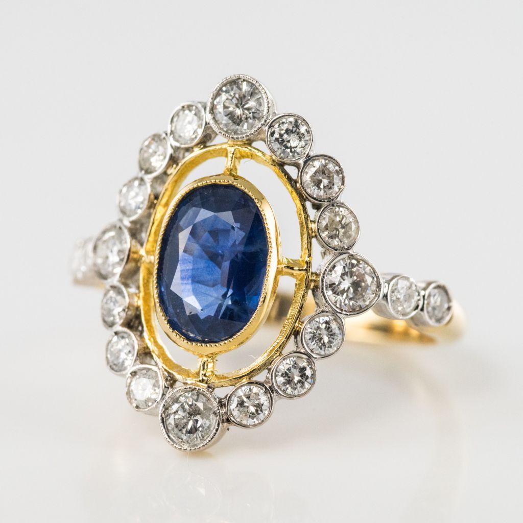 Ring in 18 carat white and yellow gold, punch eagle hallmark.

This delightful ring features a beaded bezel set oval blue sapphire with a halo of bezel set diamonds. 2 bezel set diamonds are on each side of the head. 

Total weight of sapphire: