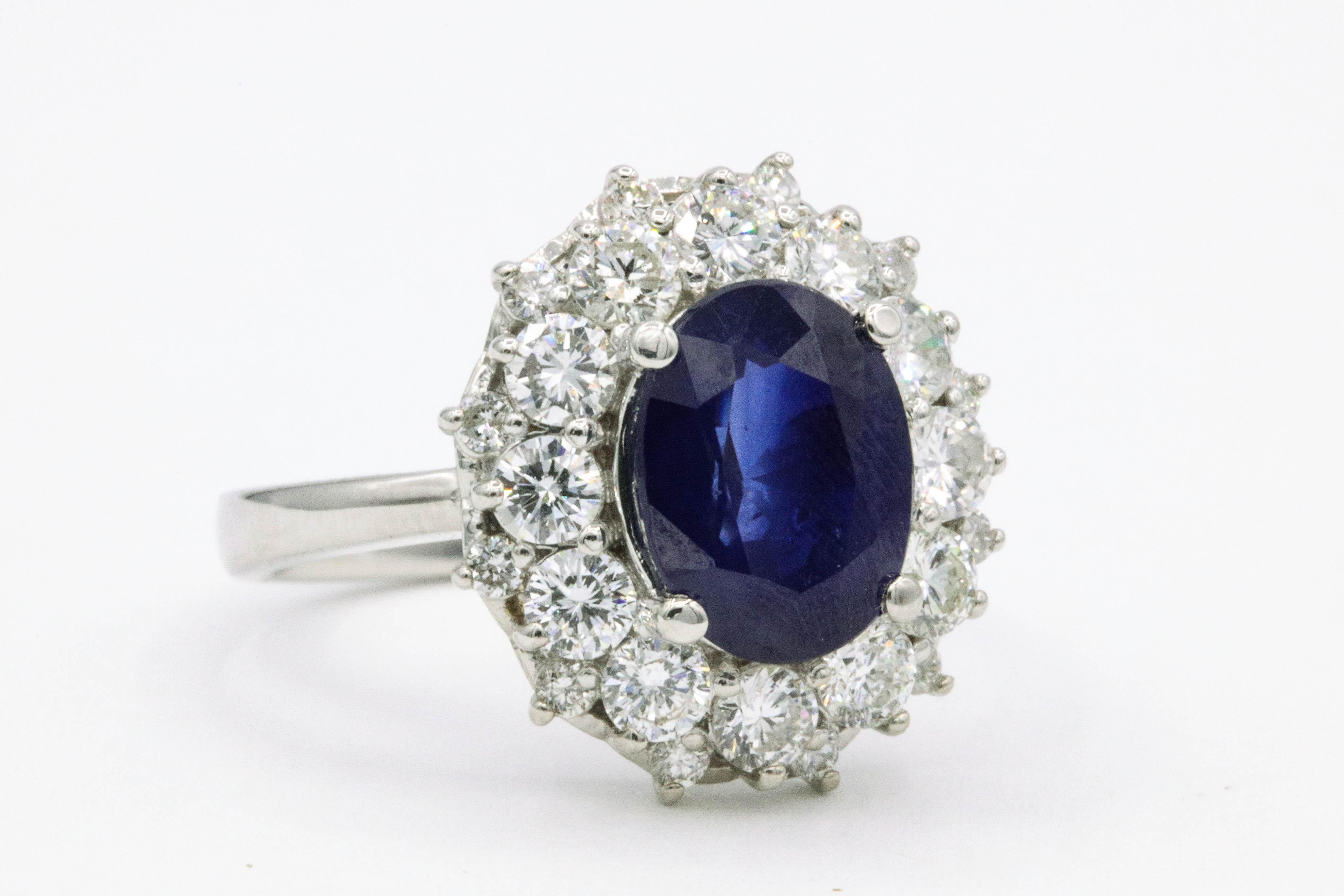 Oval sapphire weighing 3.19 carats surrounded by 24 diamonds weighing 1.40 carats, in 18k white gold. 
Color G-H
Clarity SI
Top of the ring measures 5/6