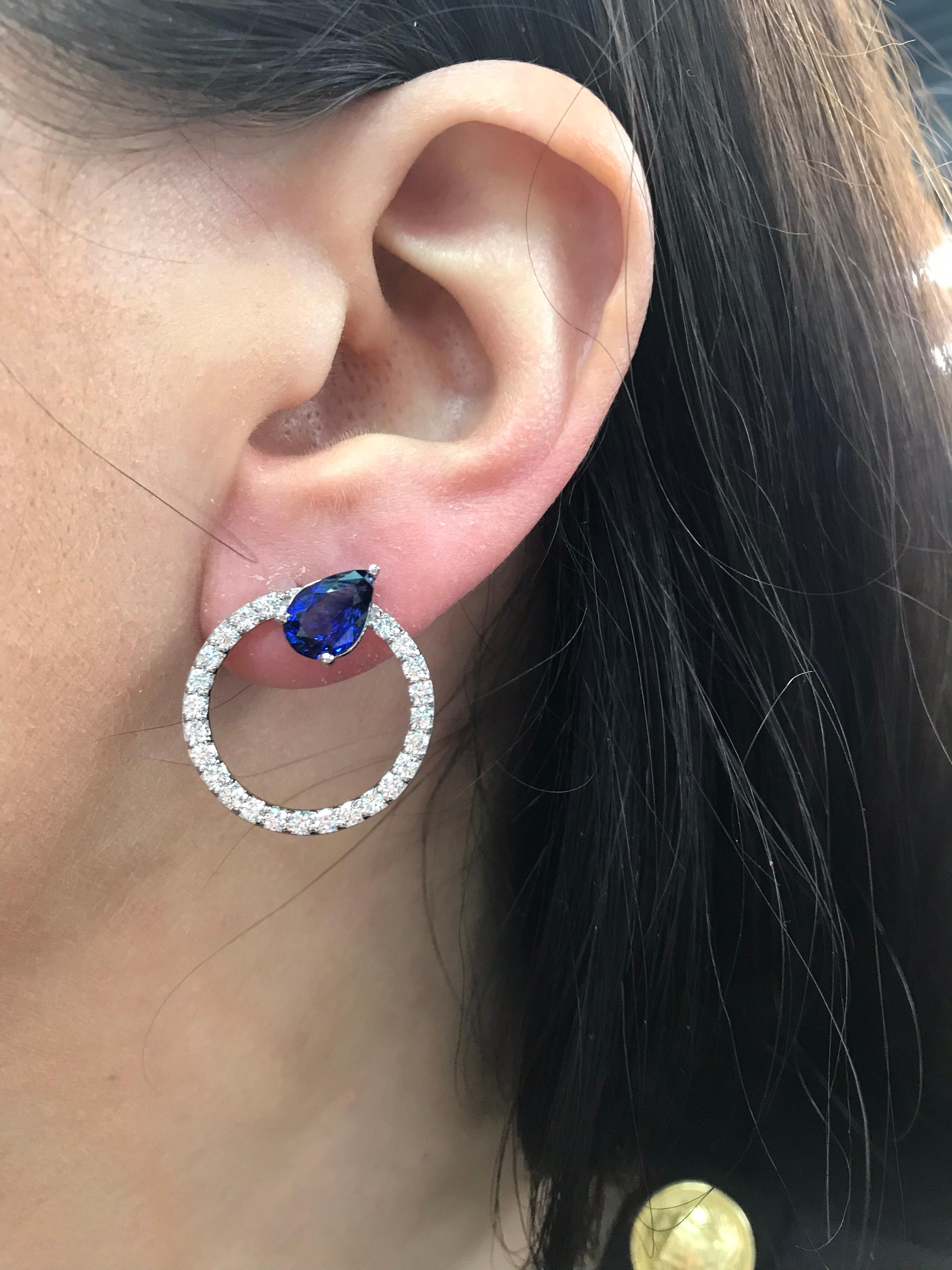 14K White gold hoop earrings featuring two pear shape Sapphires weighing 3.41 carats flanked with round brilliants weighing 1.50 carats.
