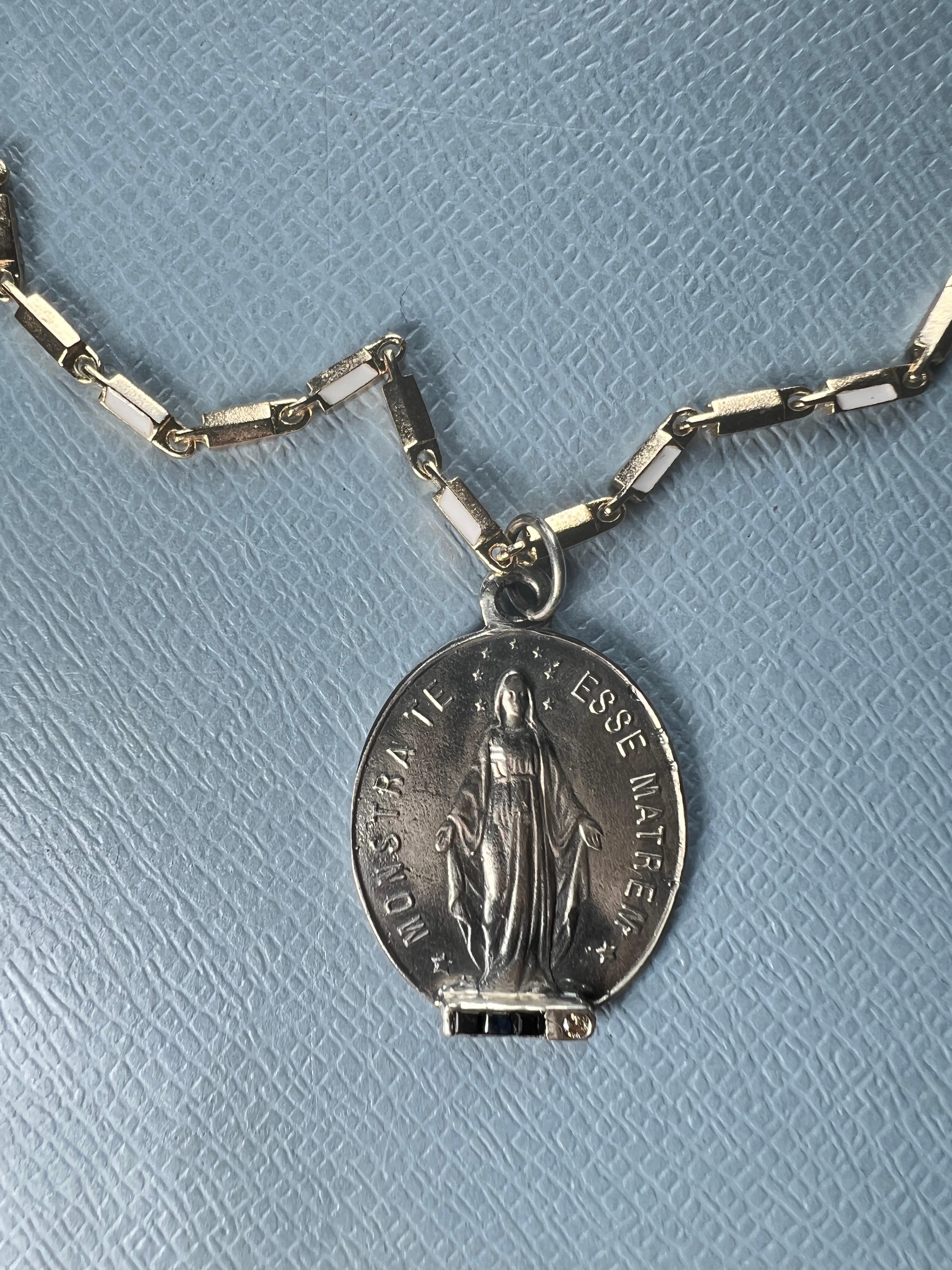 Miraculous Medal Oval Chain Necklace Sapphire Diamond 

This Oval Virgin Mary in Silver with settings of a round diamond, and 3 squares of blue sapphire and a 14k Gold Plated chain with white enamel. 

Monstra Te Esse Matrem – Show Thyself as