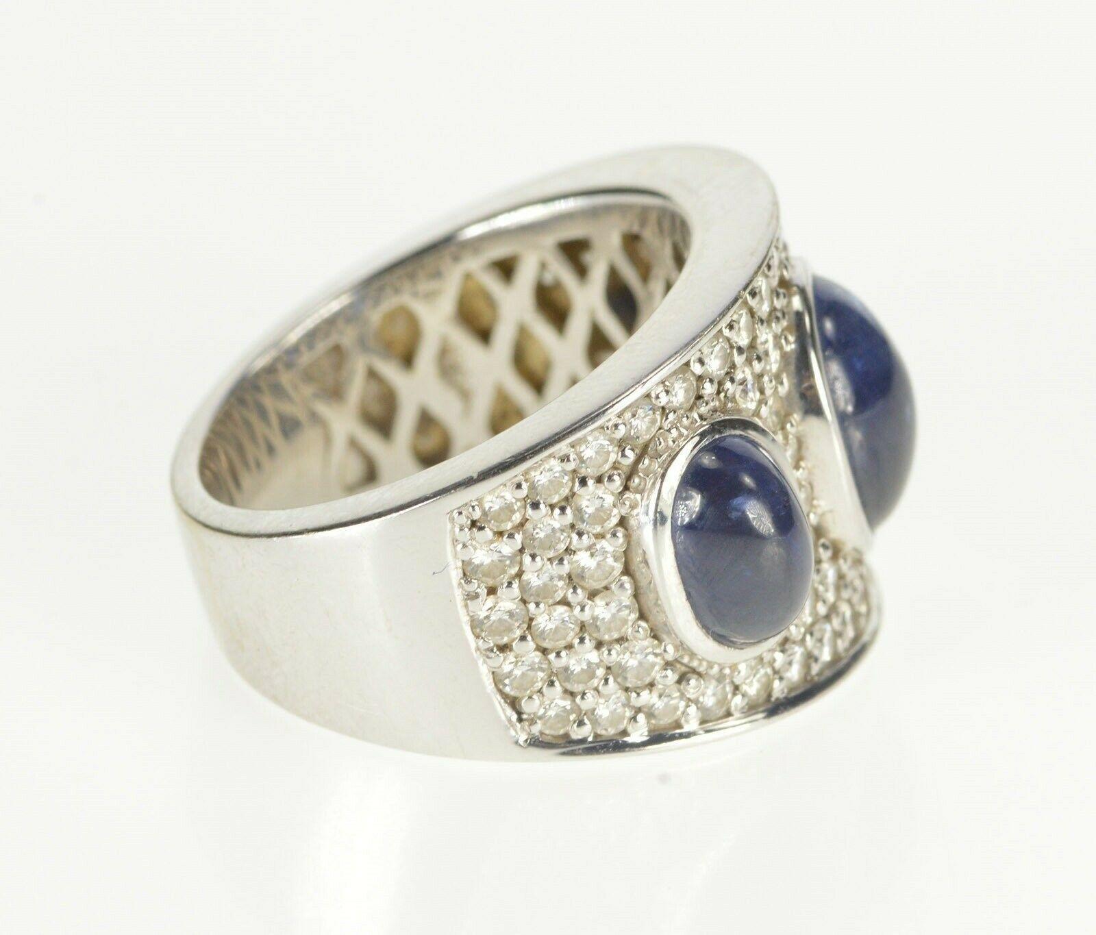 Almost 10 ctw sapphire and diamonds this classic band creates a bold statement. Currently a size 7.75, this ring is crafted out of 18k white gold. 

Gem Stone:  2.25 Ctw=74x Round Brilliant Cut Diamond 4.00 Ctw=2x Oval Cabochon Sapphire Side