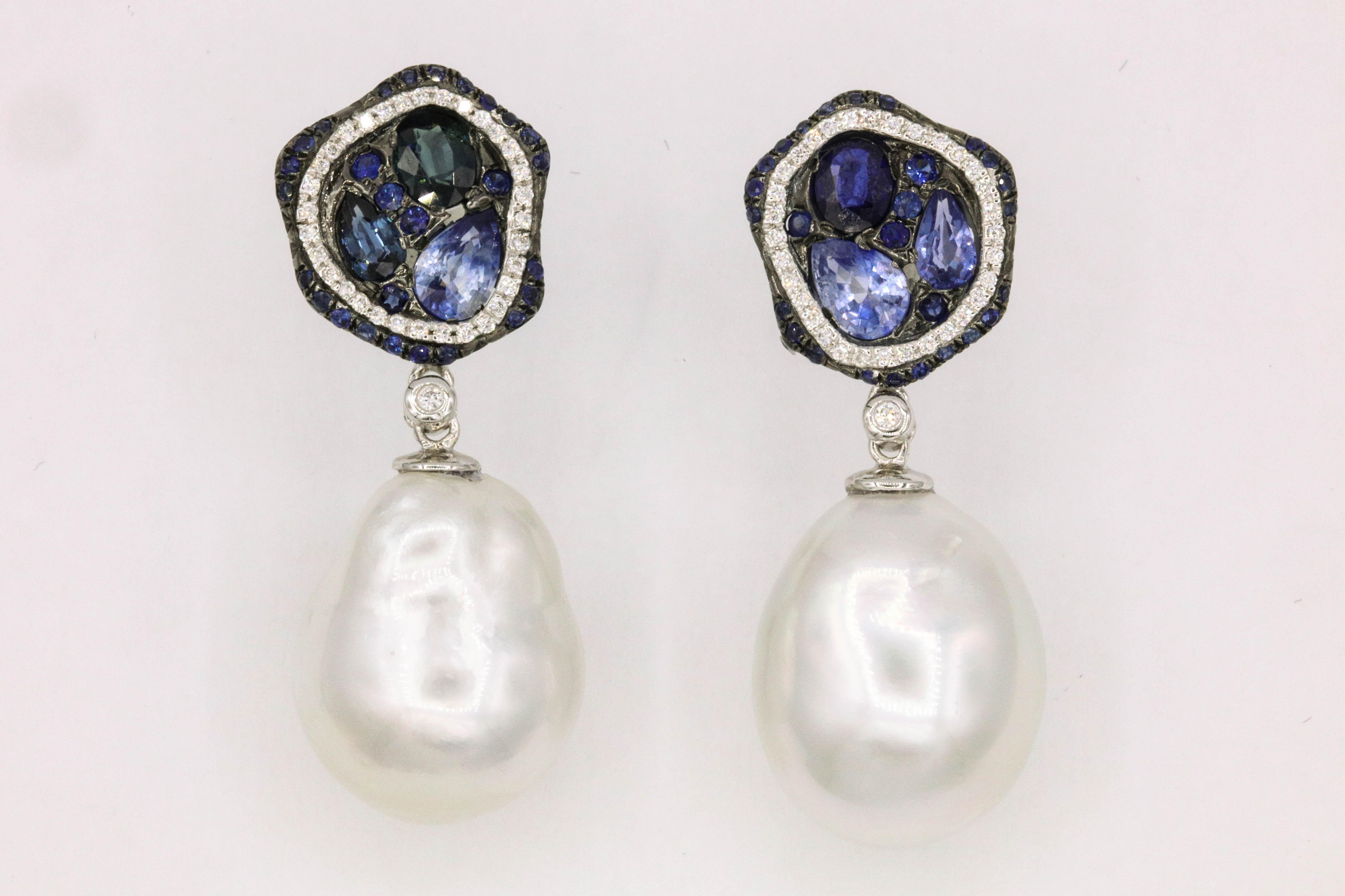 Fashionable pearl earrings featuring deep blue sapphires weighing 2.80 carats flanked with round diamonds weighing 0.23 carats, in 18k white gold. 
