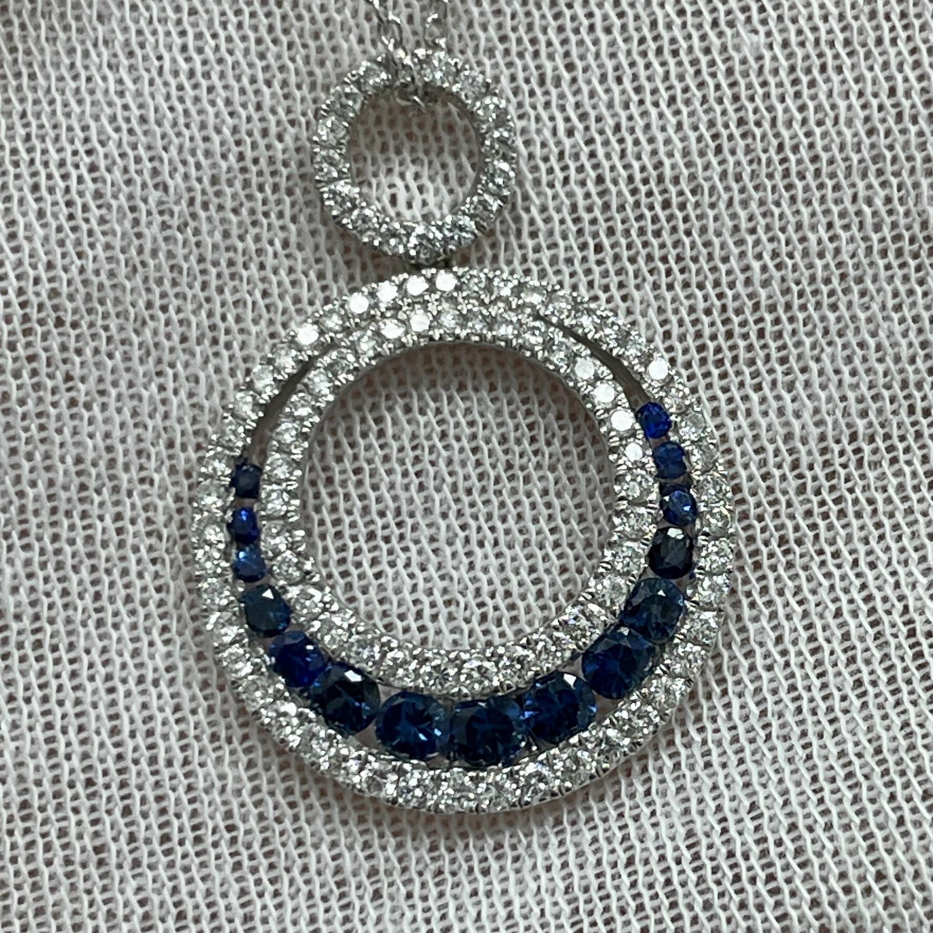 A crescent moon inspired sapphire and brilliant diamond 18K white gold pendant