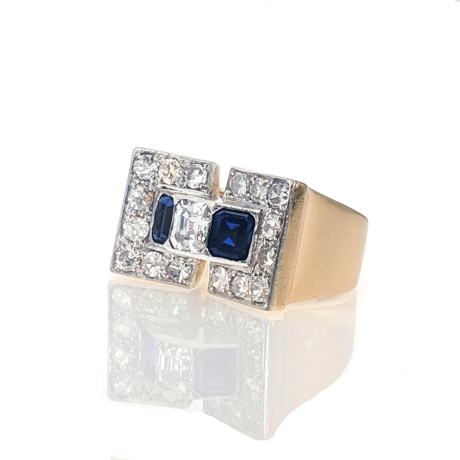 This Retro ring is of geometrical design and set with an emerald cut diamond between two rectangular step cut sapphires, in a surround of European cut diamonds. It is mounted in yellow gold and platinum and was made circa 1940.  Size 7.5. 