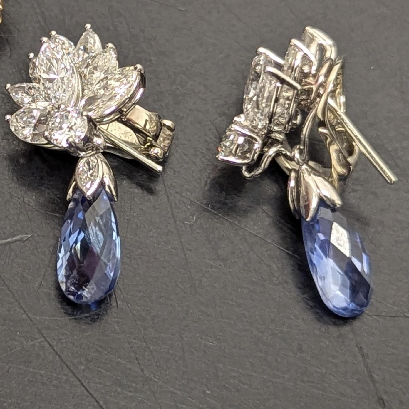 Gli orecchini di diamanti con zaffiro, lavorati in modo intricato, sono caratterizzati da zaffiri blu fiordaliso medio-chiaro, del peso di circa 12 carati, circondati da diamanti di forma rotonda e marquise di taglio europeo antico, del peso di