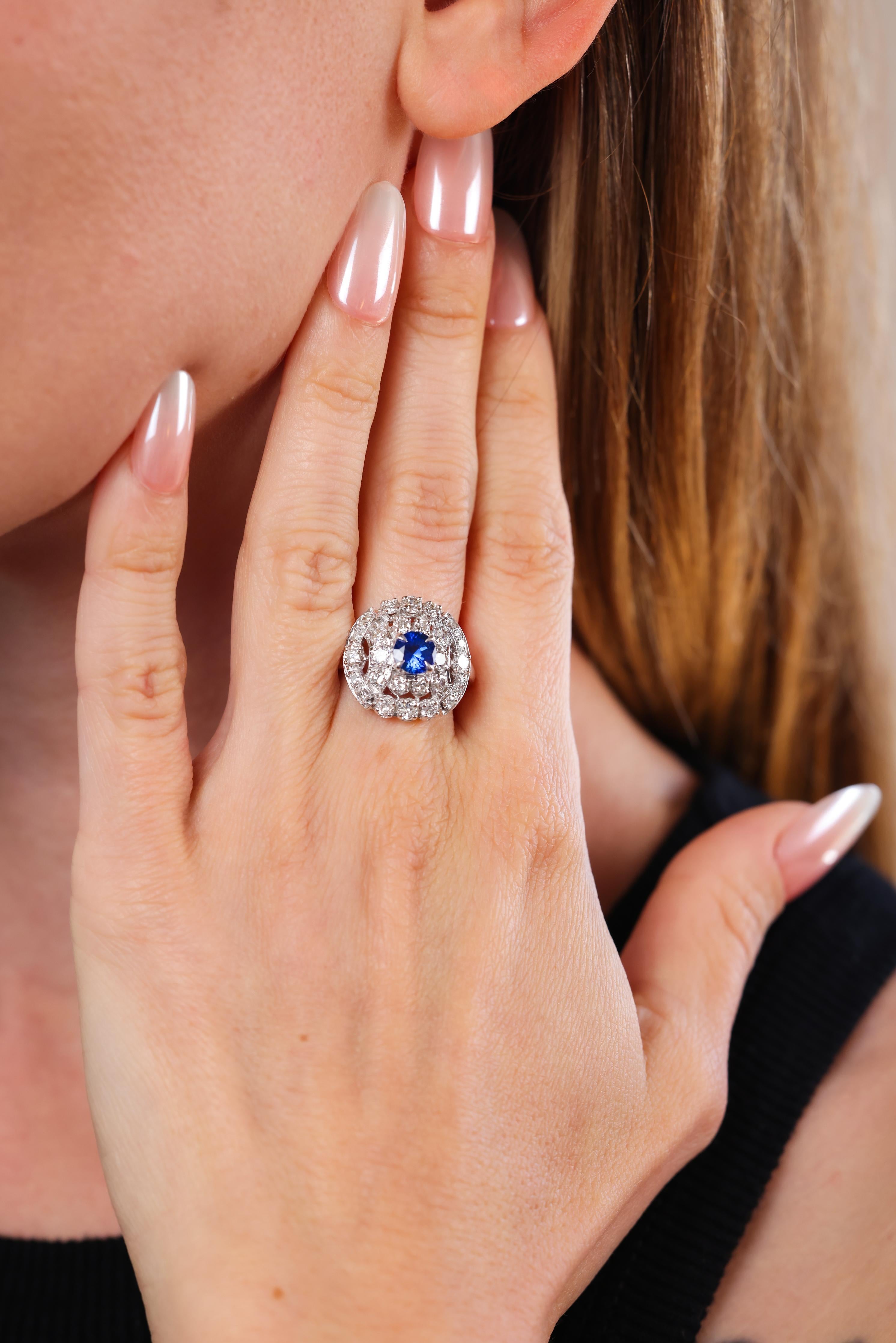 round brilliant cut blue sapphire weighing approximately 1.10 carat  
accented by 28 round brilliant cut diamonds weighing approximately 1 carat
H-I color
VS-SI clarity 
Platinum stamped with purity mark 
circa 1980s 
ring size 8 and can be resized