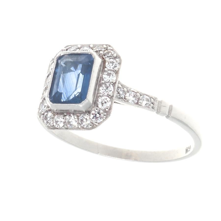The perfect way to say I love you. Featuring a 1.15 carat natural deep blue emerald cut sapphire surrounded by a halo of diamonds to accentuate the true beauty and color of the sapphire. Crafted in platinum. Ring size 7-1/4 and can easily be resized