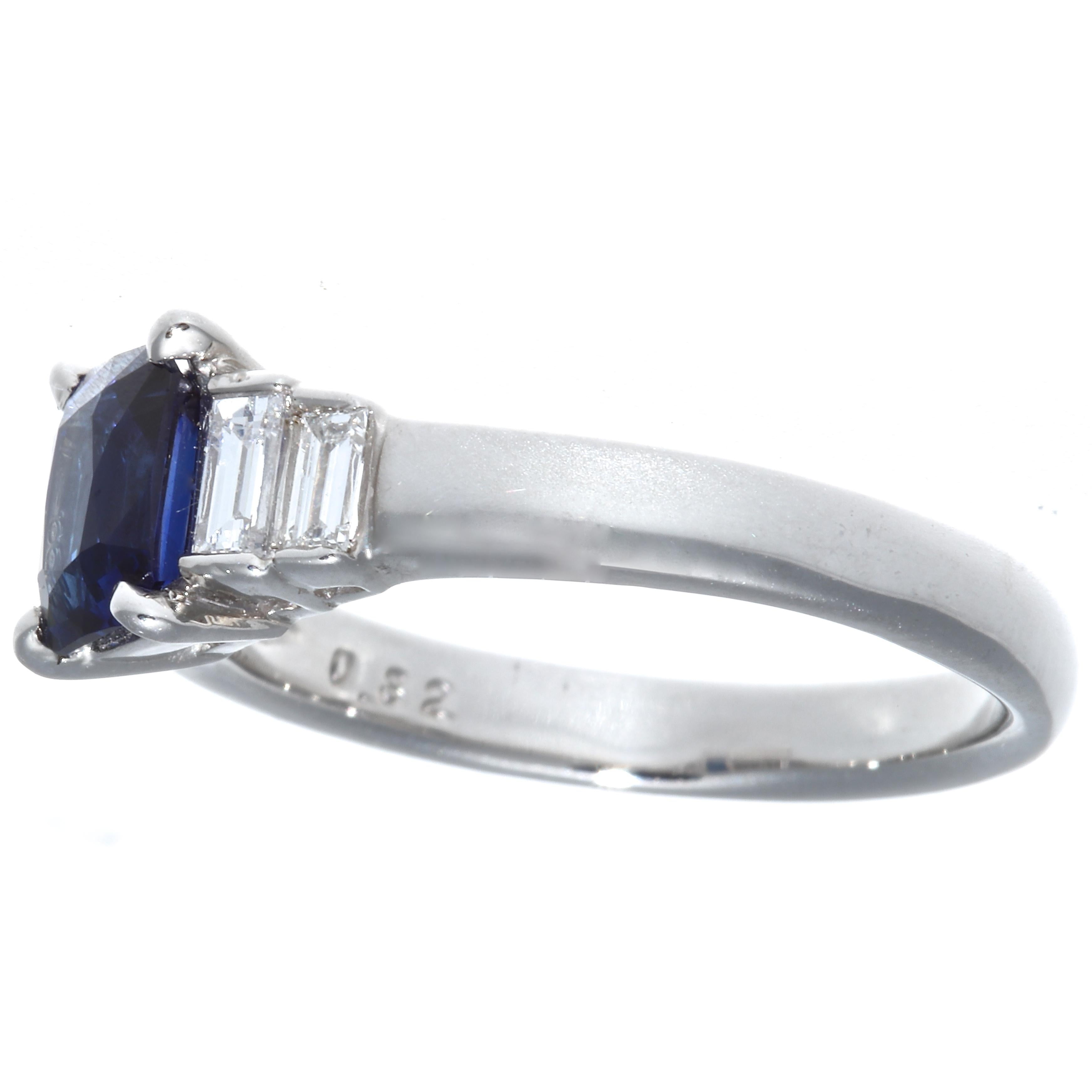 A solidly well made ring. The nicely saturated, translucent sapphire weighs 1.07 carats. The accenting 4 emerald cut diamonds weigh 0.32 carats, D,E color, VVS clarity. The ring is platinum, size 6 1/2 and may easily be re-sized to fit. 
Flawless