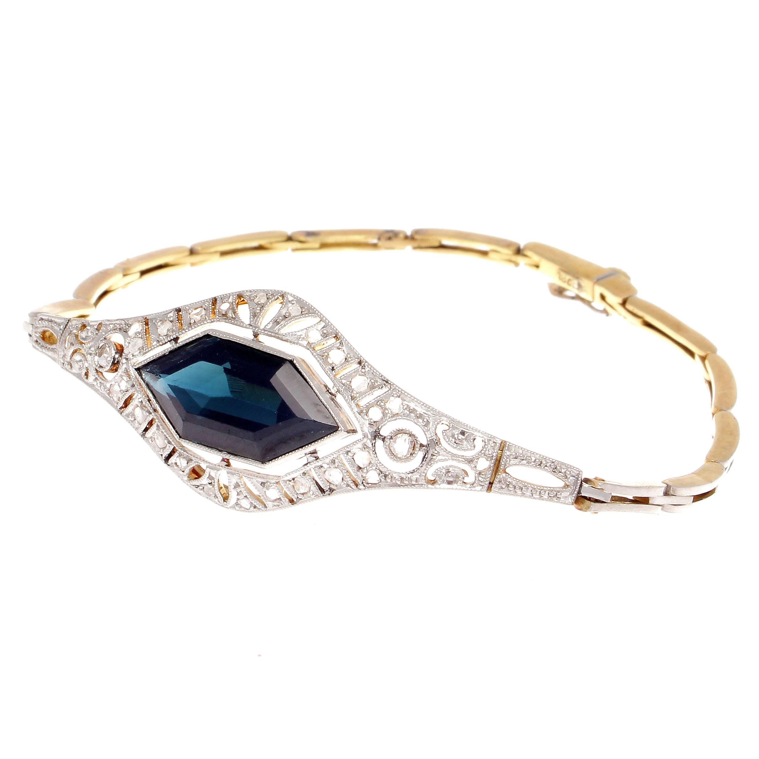Embracing and producing everything that was beautiful during the Art Deco golden era of jewelry.  Featuring a specialty cut deep navy blue sapphire that is approximately 4.50 carats thoughtfully surrounded by perfectly placed old cut diamonds. Hand