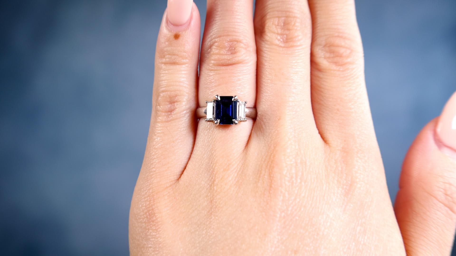 One Sapphire Diamond Platinum Ring. Featuring one octagonal step cut sapphire of 1.25 carats. Accented by two baguette cut diamonds with a total weight of 0.50 carat, graded F-G color, VS clarity. Crafted in platinum with purity mark and gemstone