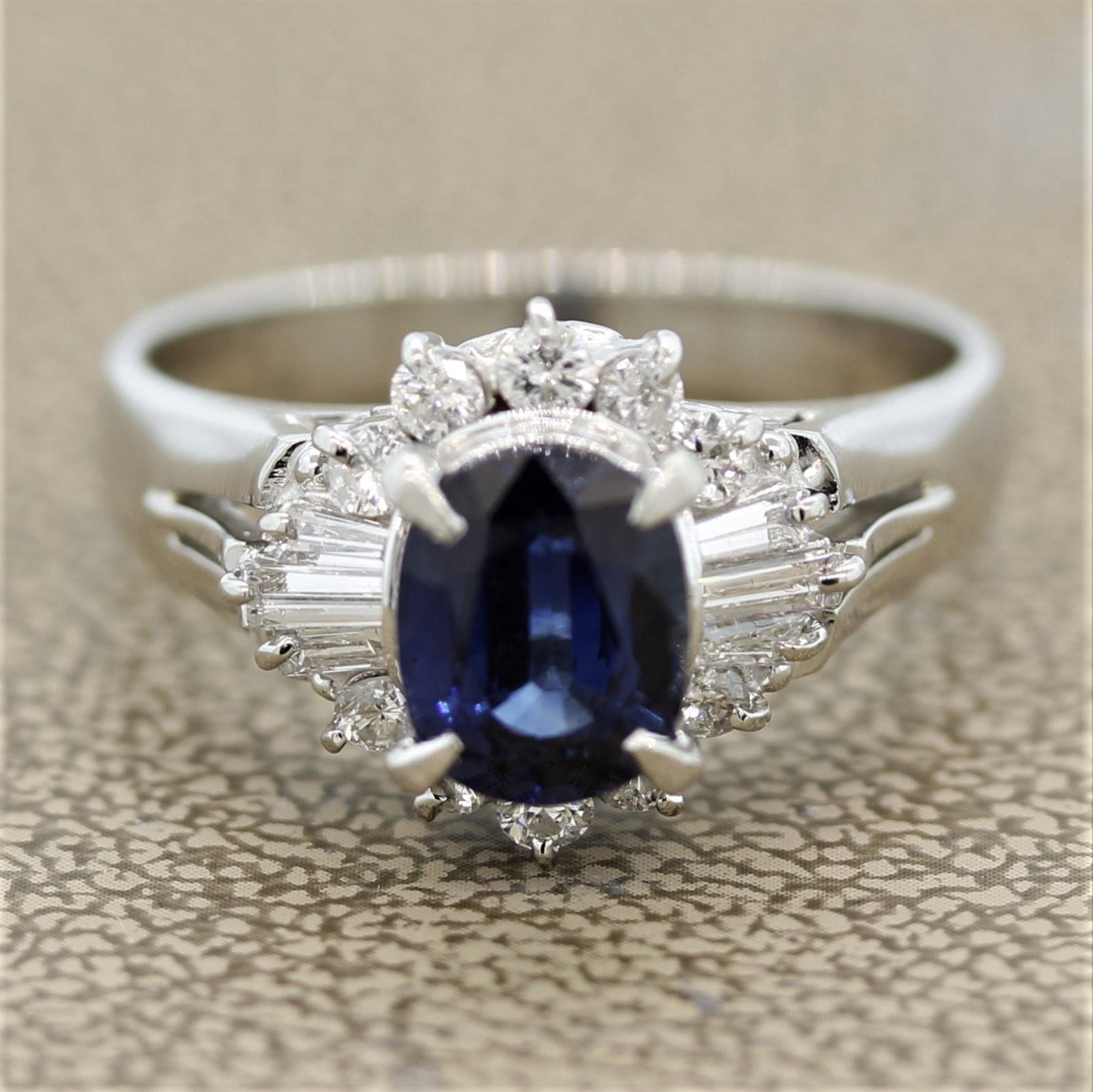 Une belle bague avec un saphir de forme ovale de 2,07 carats. Elle présente une couleur bleue douce et vive, sans inclusions visibles. Il est entouré de 0,61 carats de diamants baguette et ronds de taille brillant, sertis autour du saphir selon un