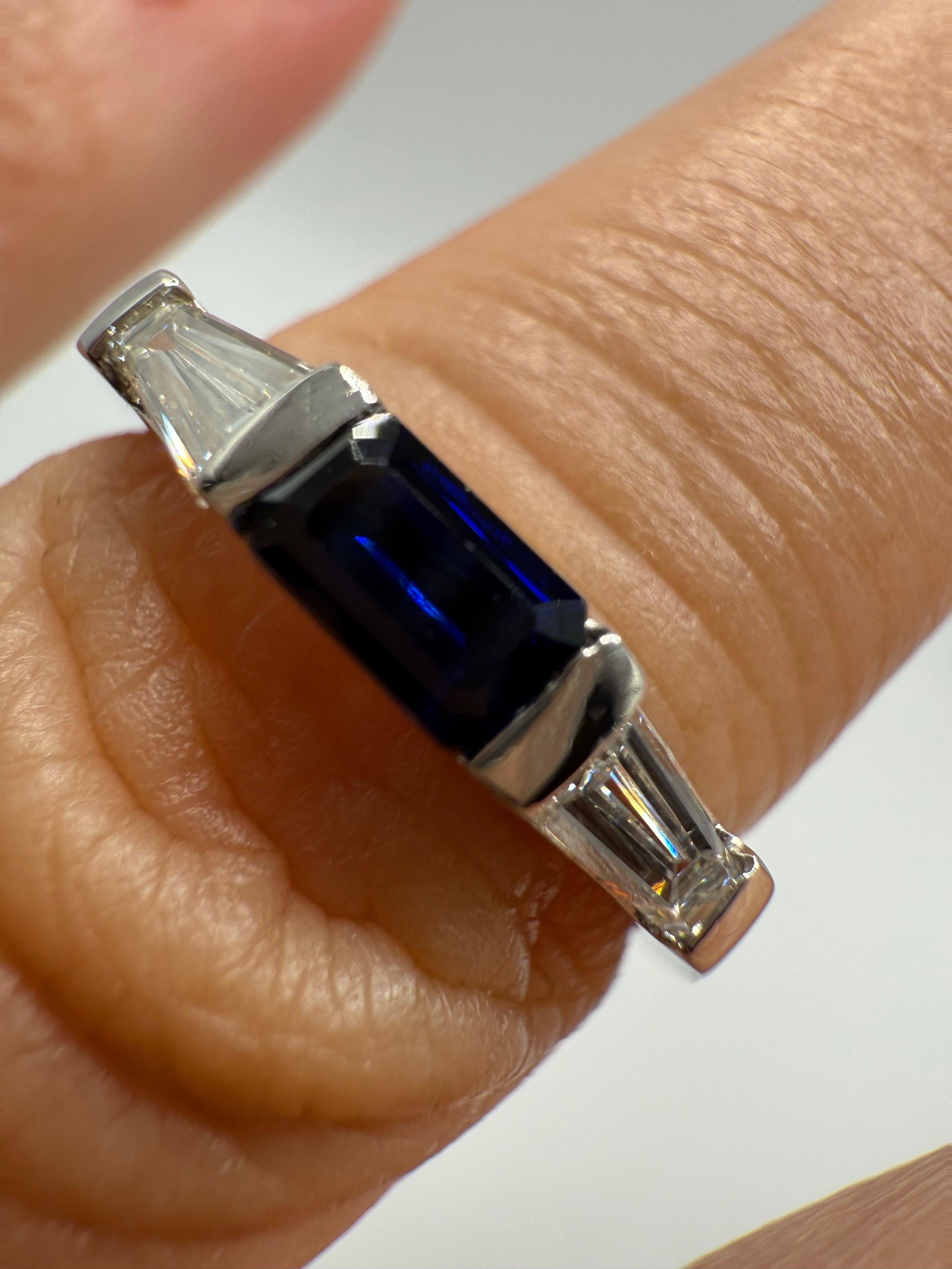 Magnifique bague saphir diamant de conception française, très belle seule ou comme alliance, composée d'un saphir de couleur bleu royal au centre, d'un saphir taillé en escalier, de couleur moyenne à foncée, et de diamants blancs sur les côtés,