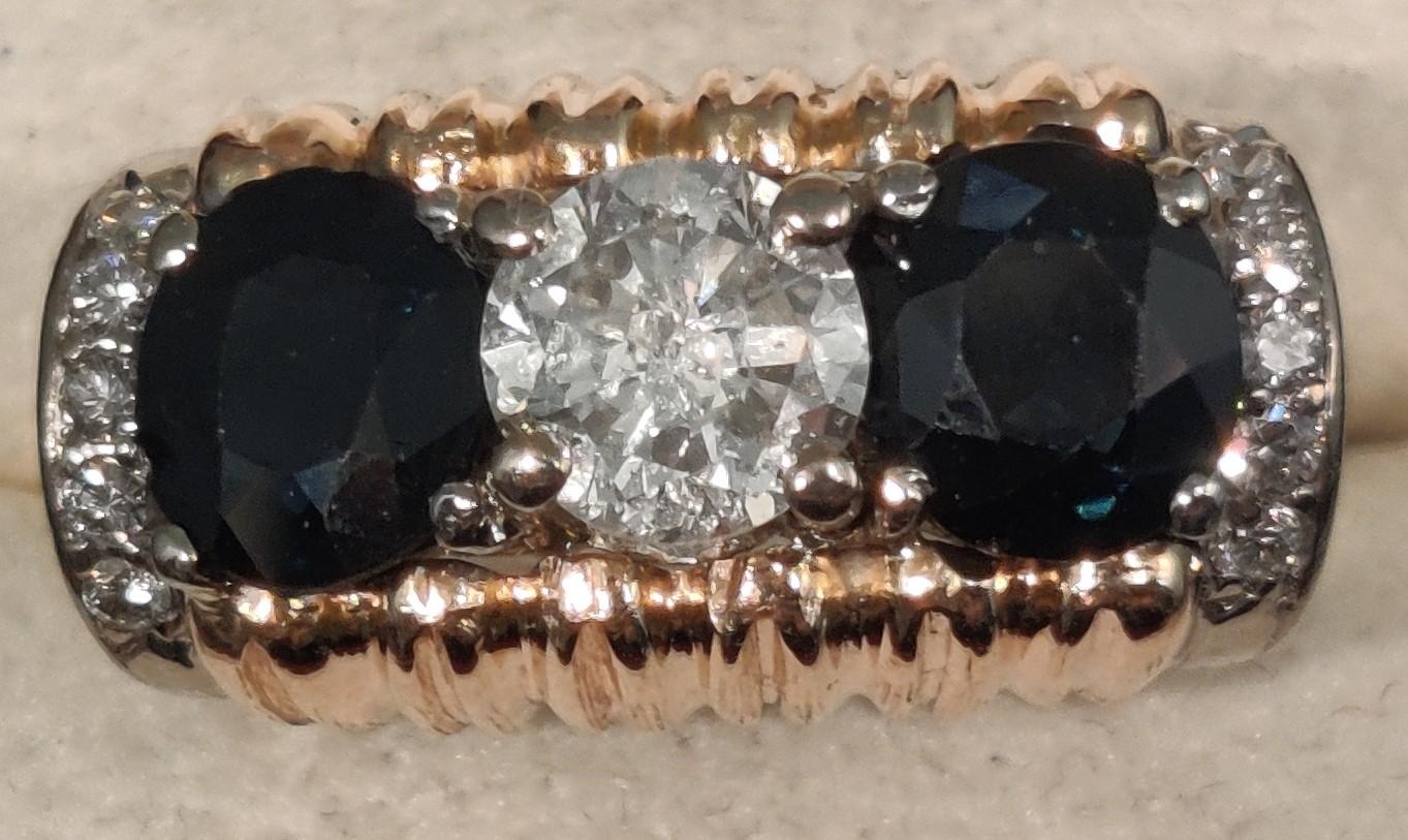 18 ct Gold
center one diamond ca 0,75 ct 
right and left. 2. dark sapphire ca 1,5 ct
left and right each side 5 small diamonds
on top ca 1 cm
ring size 56,5
weight 9,9 grams